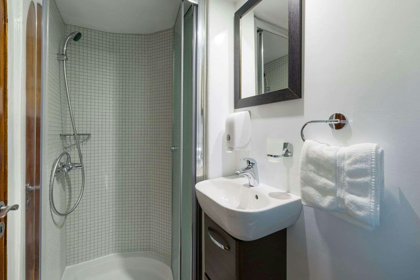 a bathroom with a sink and a shower aboard LINDA Yacht for Charter