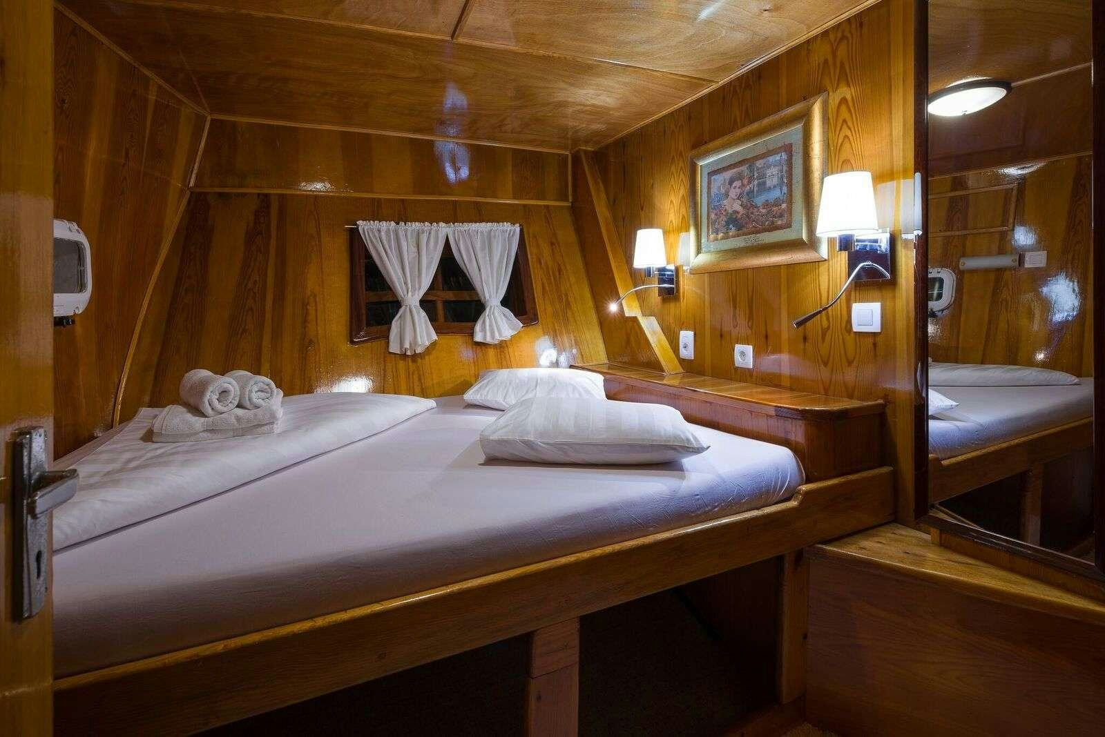 a bed with a white sheet and a white sheet on it aboard LINDA Yacht for Charter