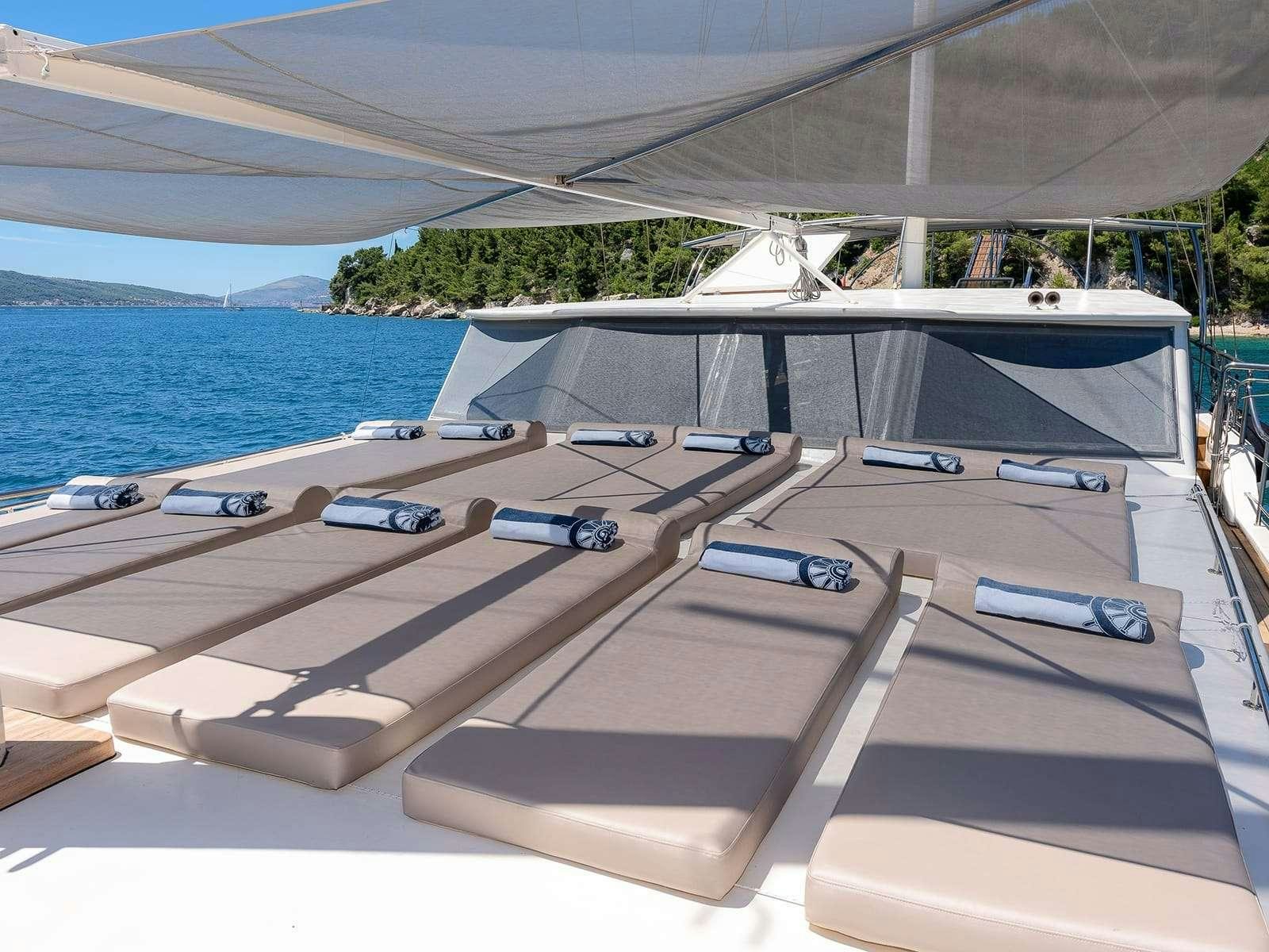 a deck with a view of the ocean and a boat on it aboard Gulet Nautilus Yacht for Charter