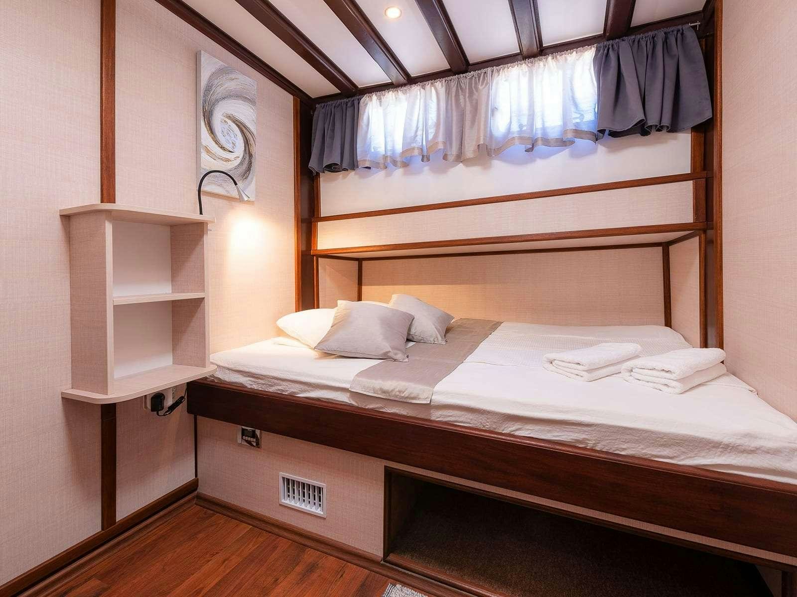a room with a bed and a shelf aboard Gulet Nautilus Yacht for Charter