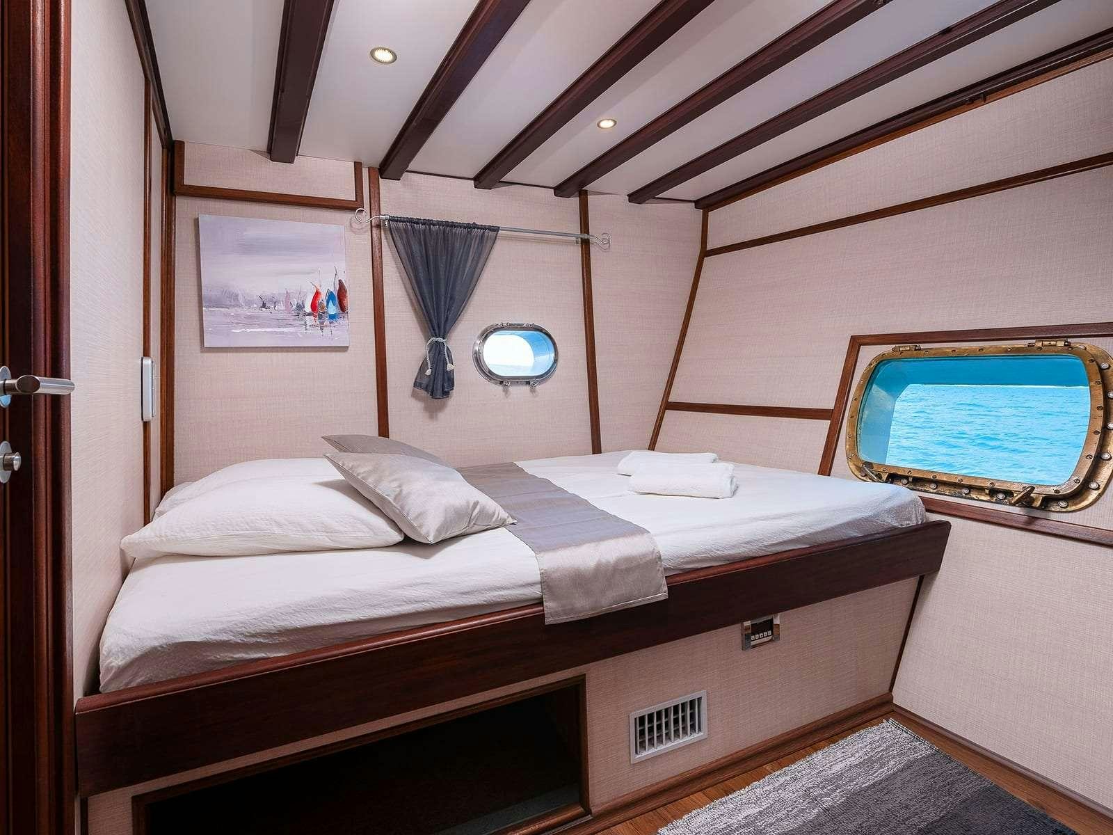 a room with a bed and a window aboard Gulet Nautilus Yacht for Charter