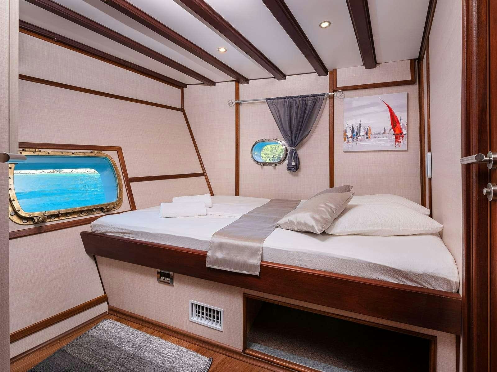 a room with a bed and a television aboard Gulet Nautilus Yacht for Charter
