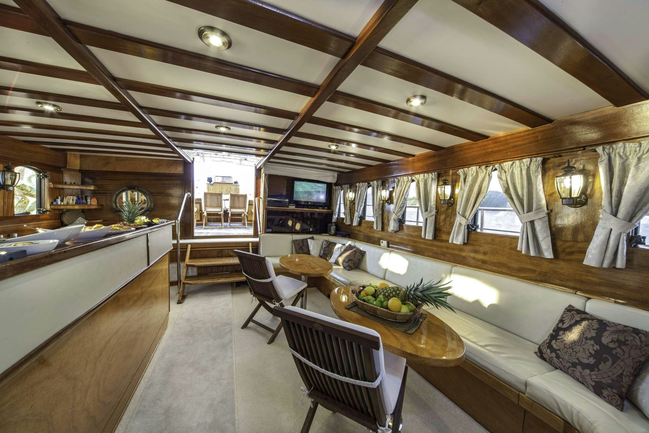 a large room with a bed and a table aboard LIBRA Yacht for Charter