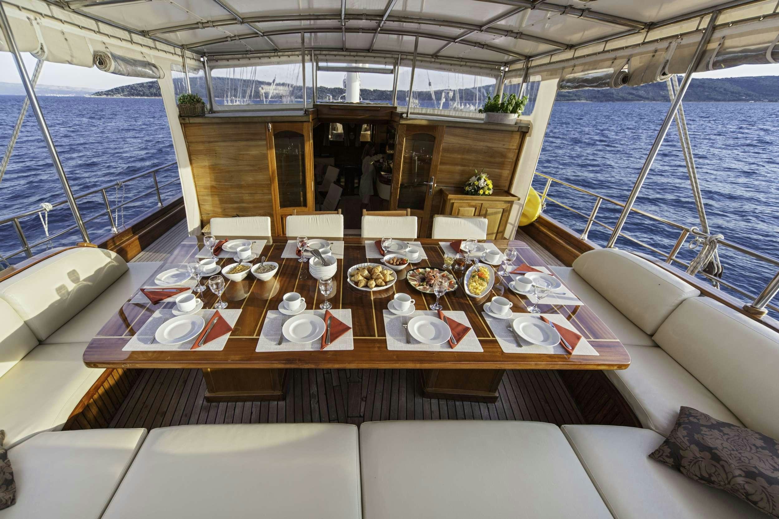 a table set for a dinner party aboard LIBRA Yacht for Charter