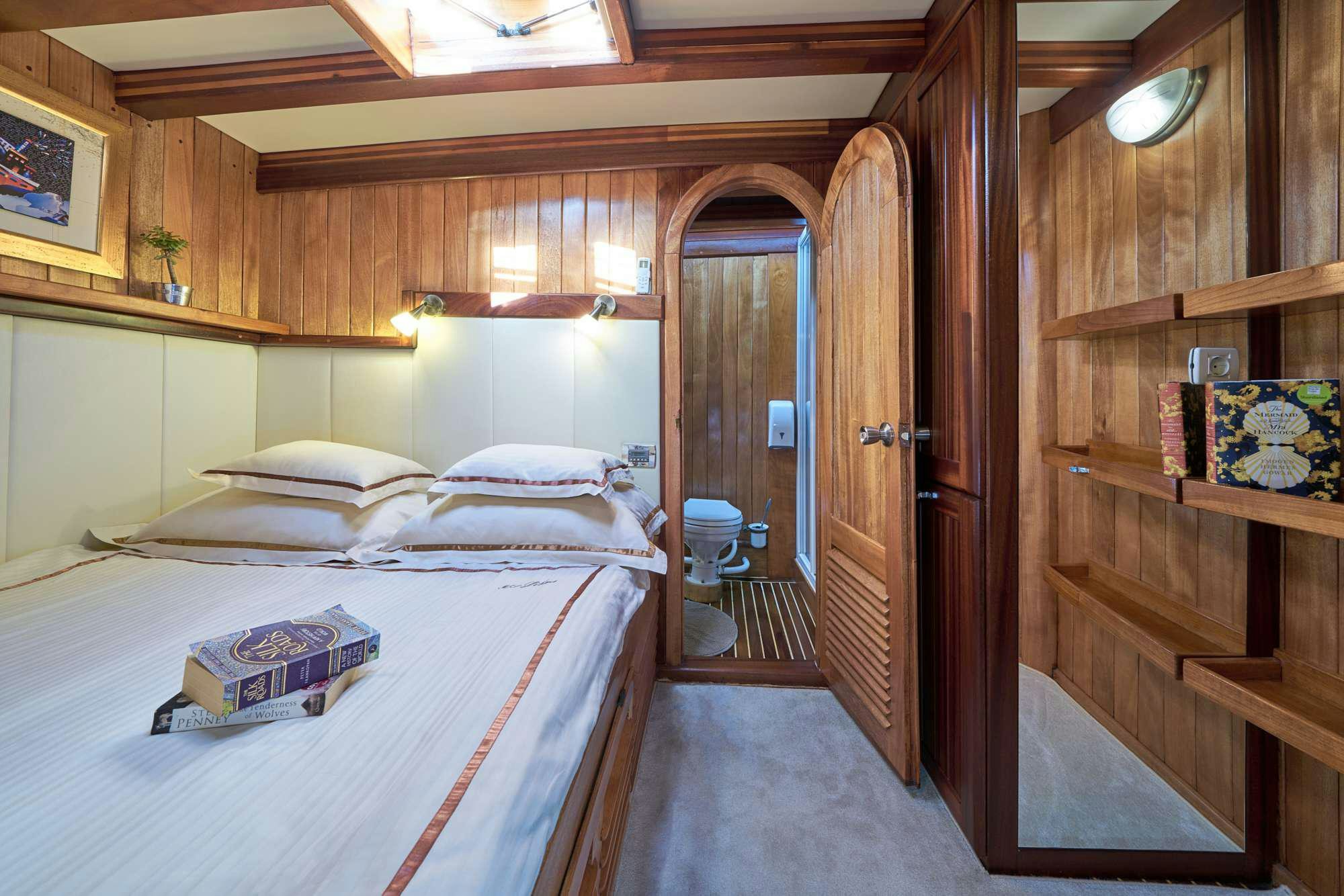 a room with a bed and a closet aboard LIBRA Yacht for Charter
