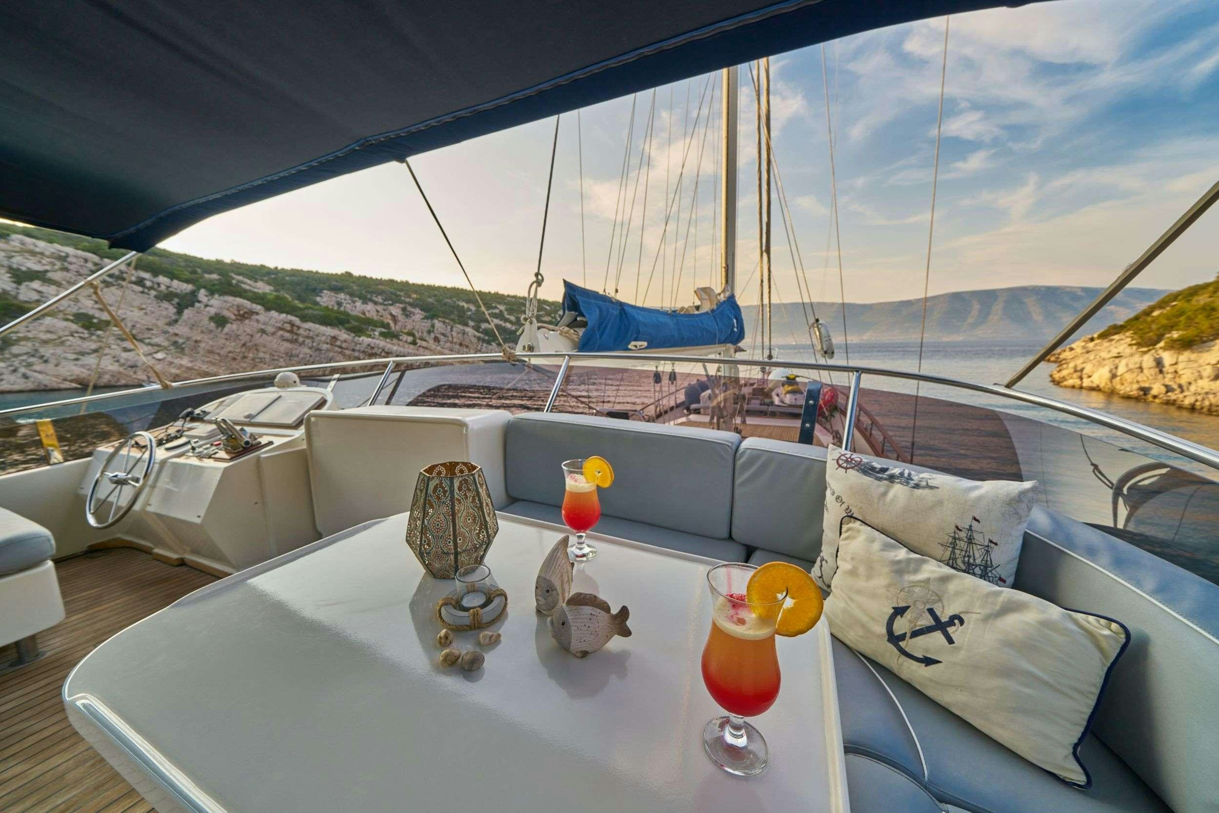 a table with candles and a view of the mountains aboard LOTUS Yacht for Charter