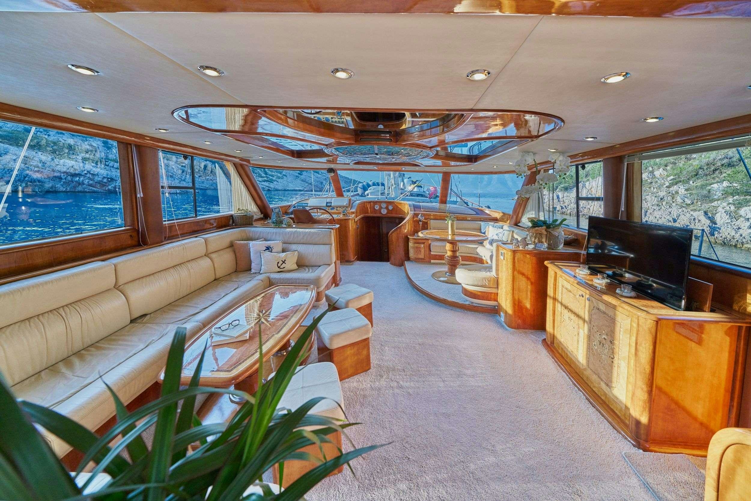 a room with a large window and a tv in it aboard LOTUS Yacht for Charter