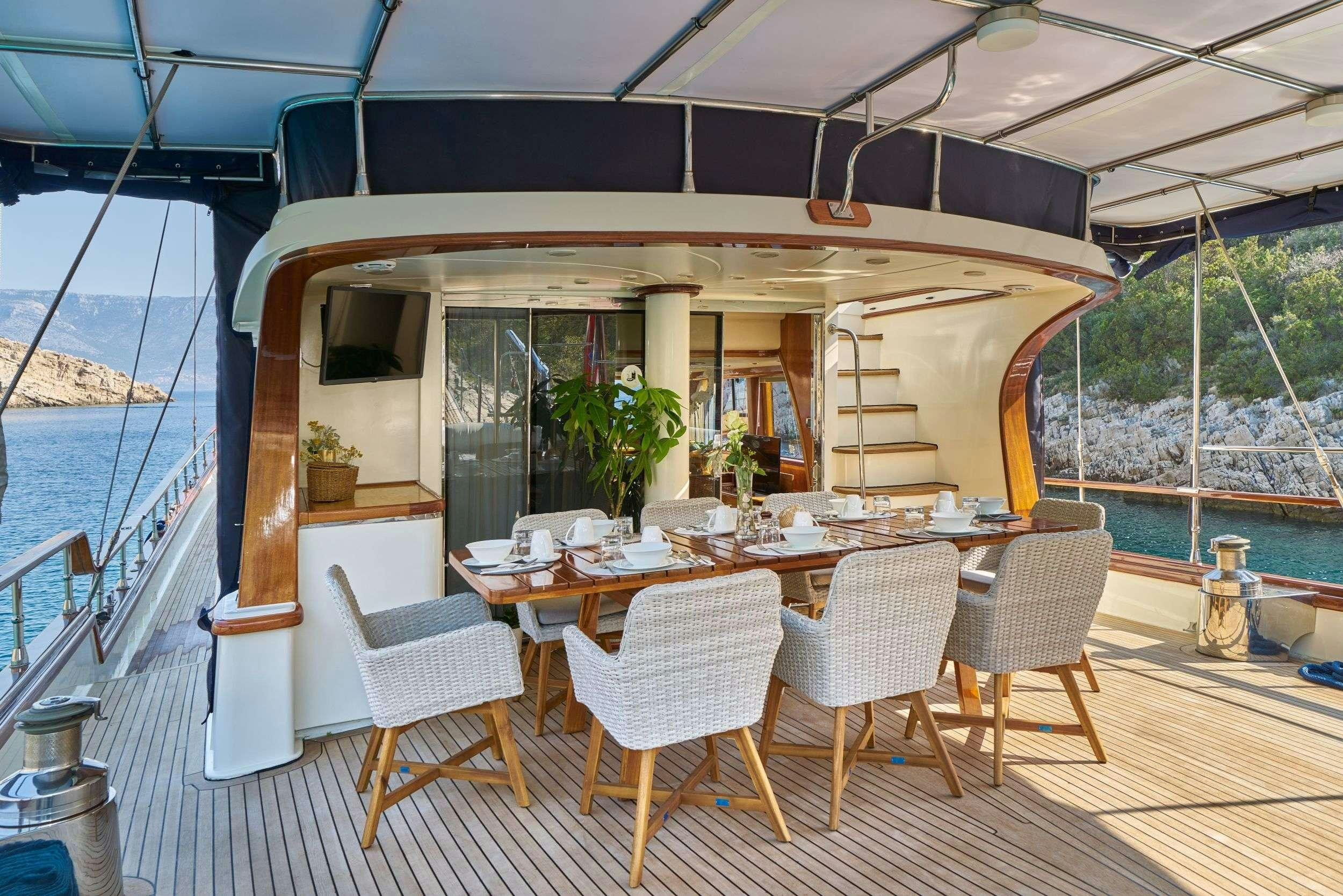 a table and chairs on a deck aboard LOTUS Yacht for Charter