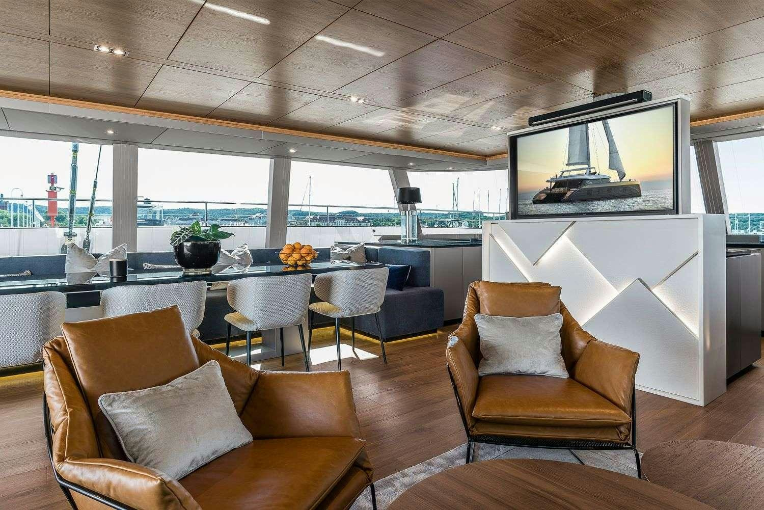 a room with a table chairs and a tv aboard 7X Yacht for Charter