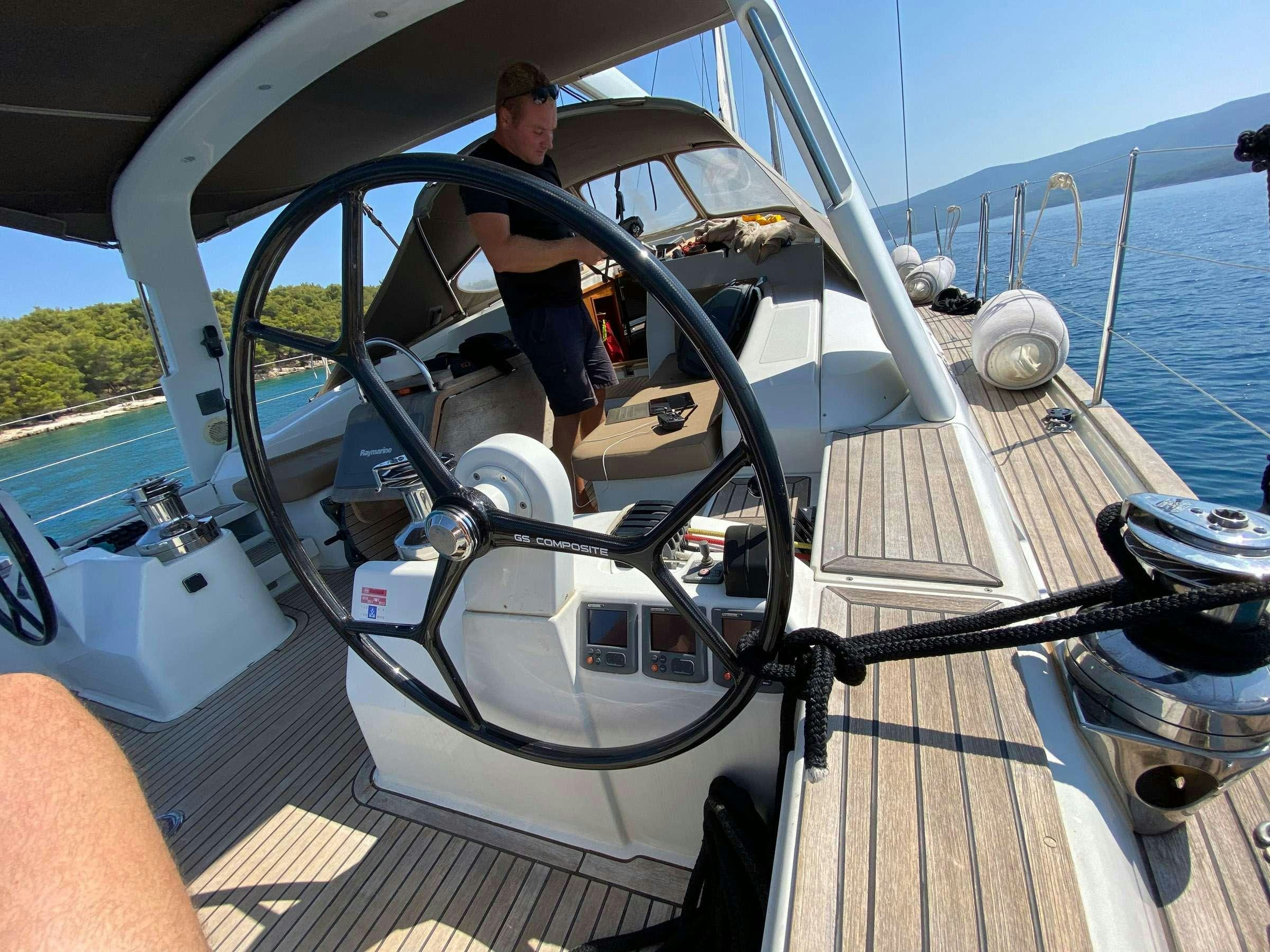 a person sitting on a boat aboard ADIQELL (Pilot Saloon 55) Yacht for Charter