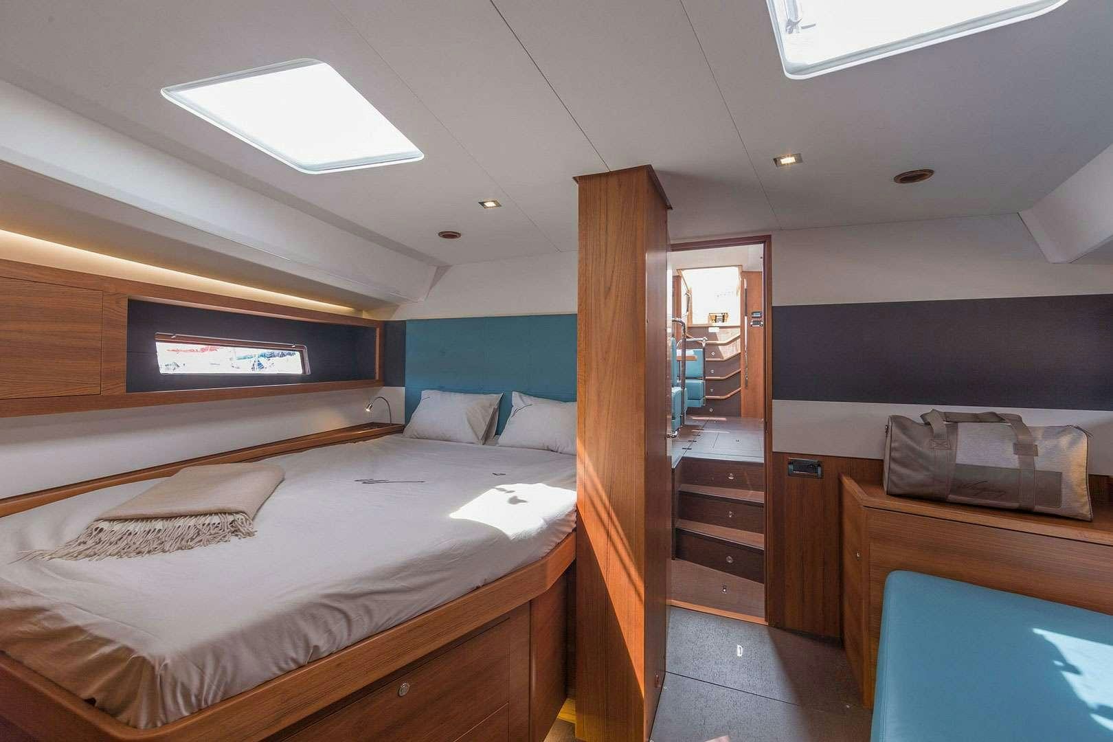 a room with a bed and a dresser aboard ADIQELL (Pilot Saloon 55) Yacht for Charter