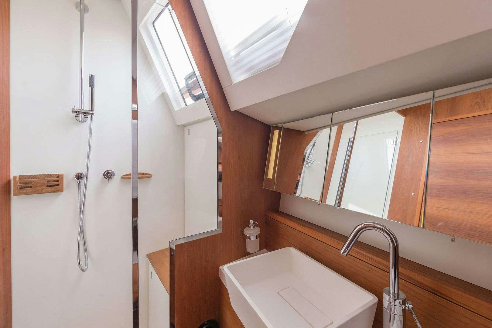 a bathroom with a sink and a mirror aboard ADIQELL (Pilot Saloon 55) Yacht for Charter