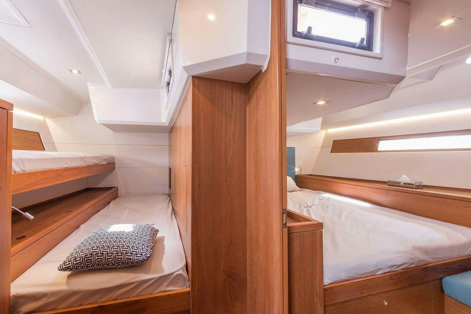 a room with a bed and a window aboard ADIQELL (Pilot Saloon 55) Yacht for Charter