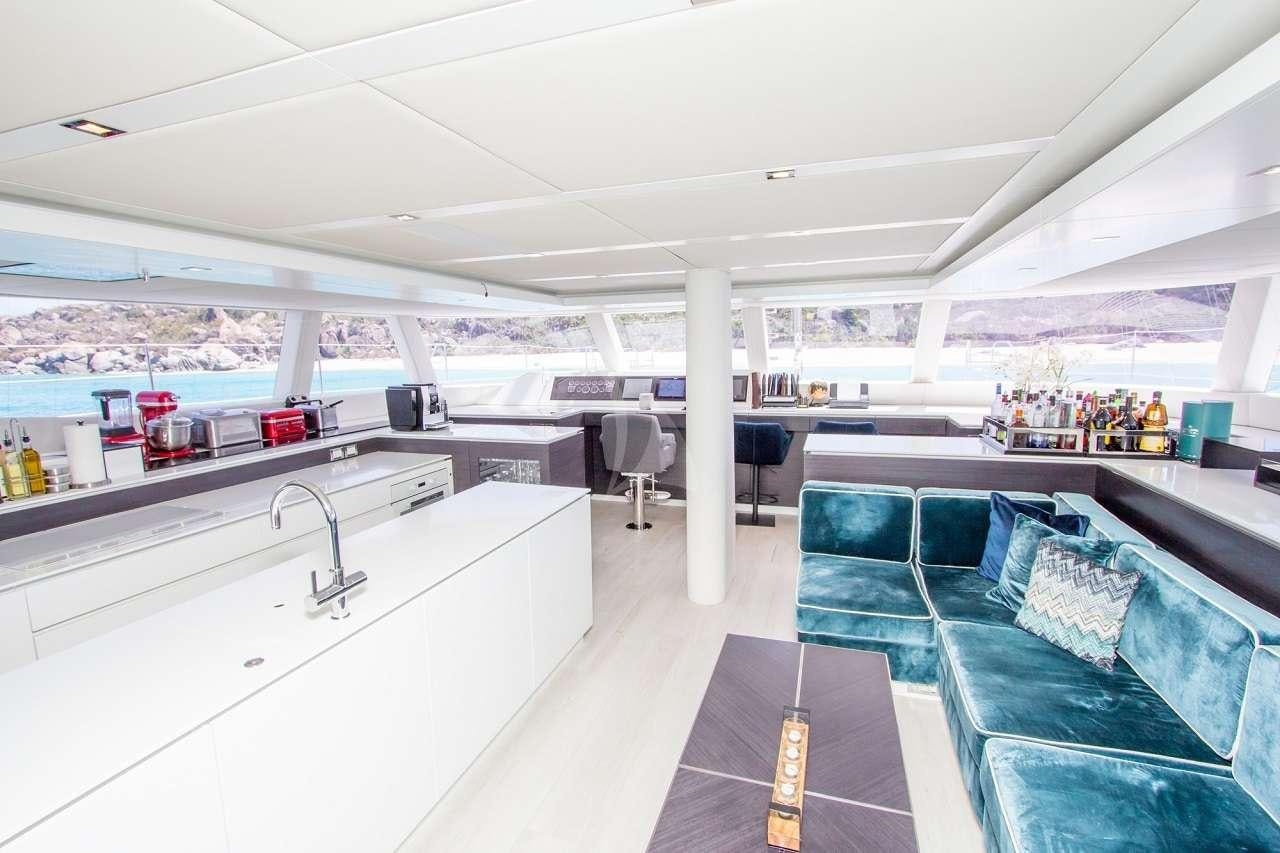 a room with a blue couch and a white table and chairs aboard ORION Yacht for Charter