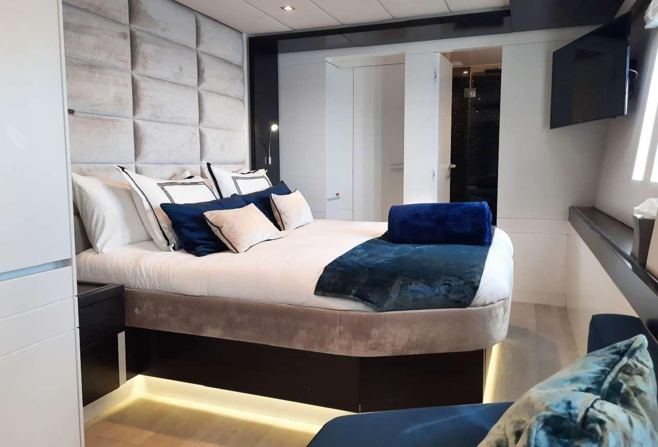 a bed with a blue pillow aboard ORION Yacht for Charter
