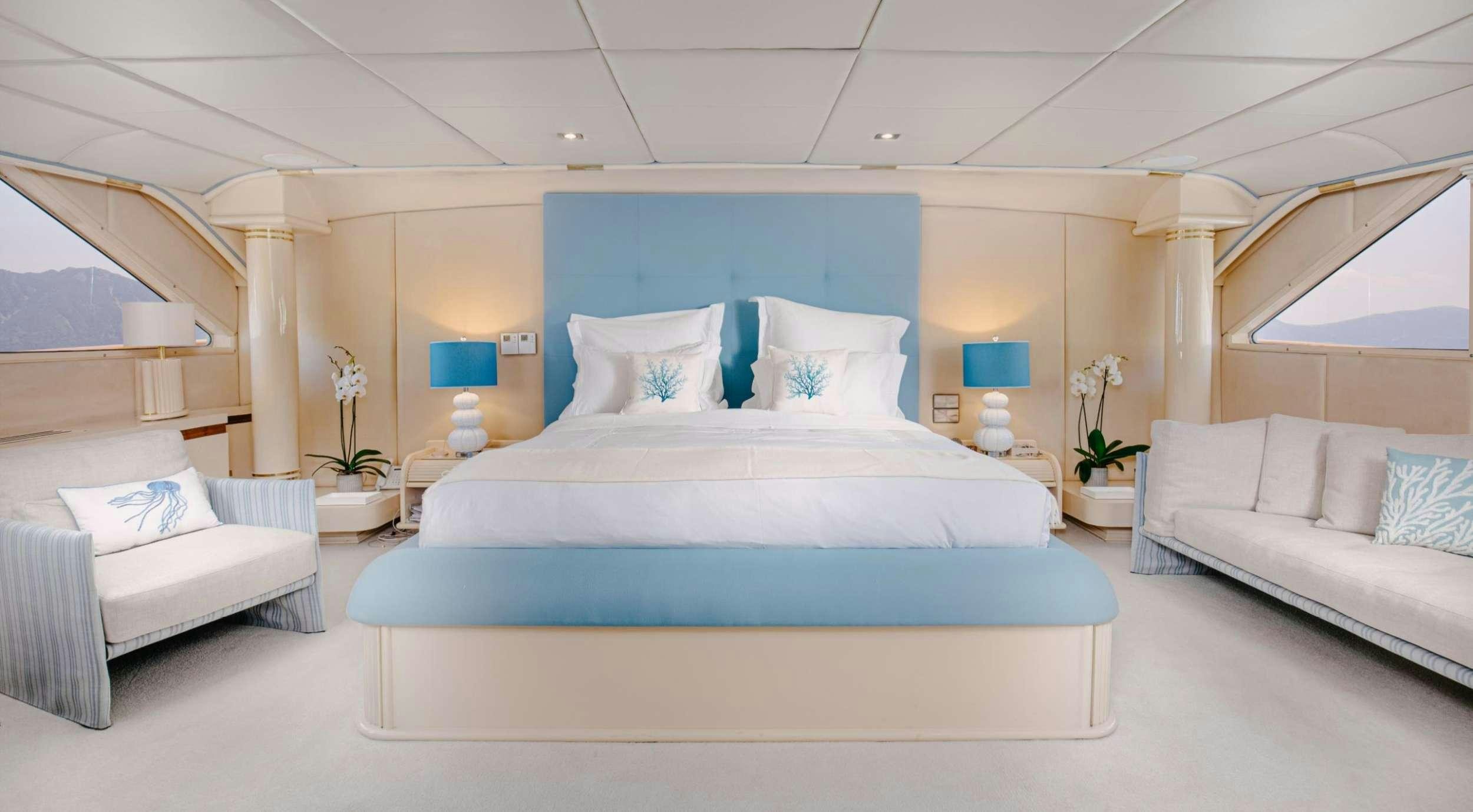 a modern bedroom with a blue bed aboard ITOTO Yacht for Charter