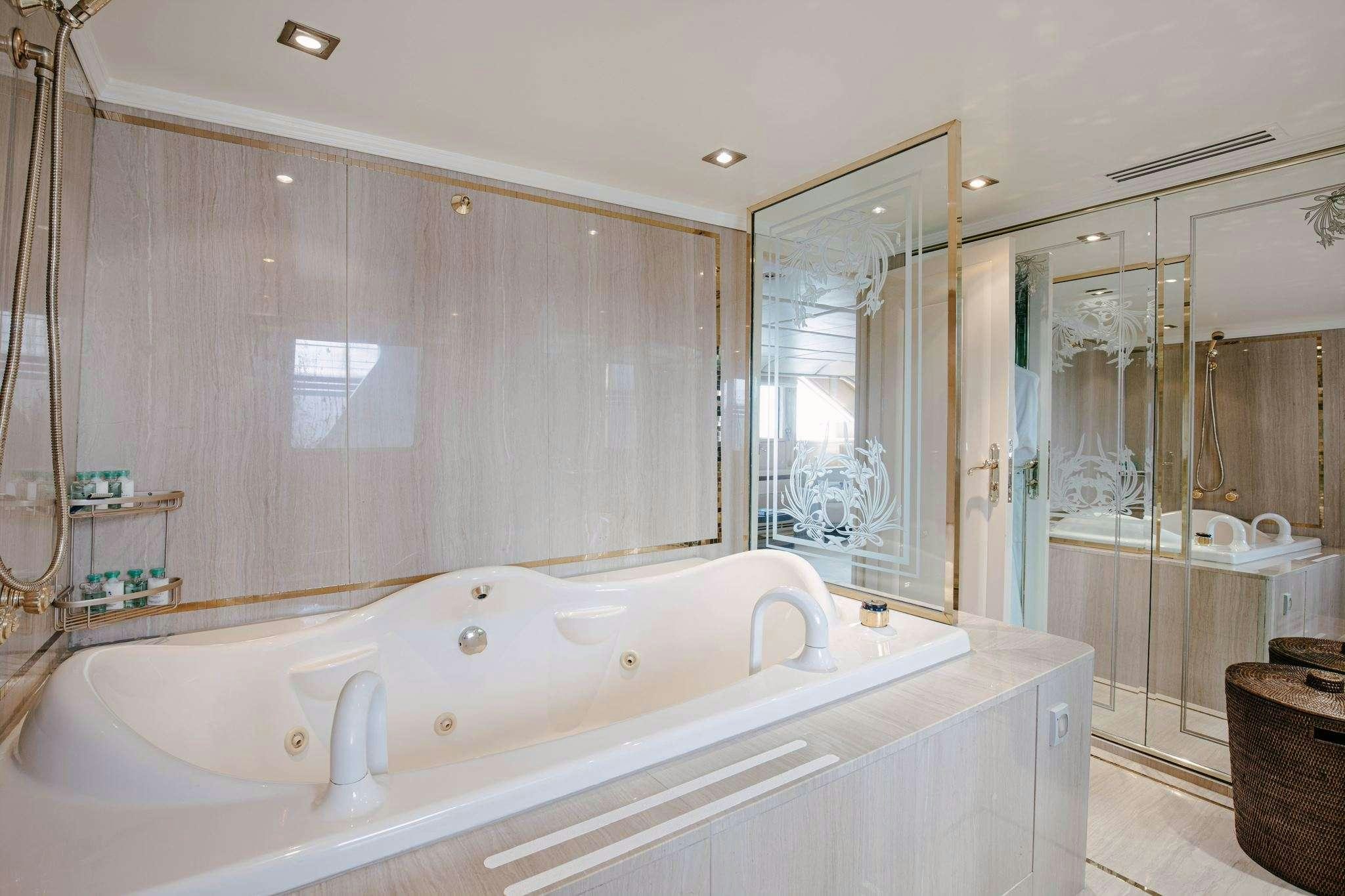 a bathroom with a bathtub and shower aboard ITOTO Yacht for Charter