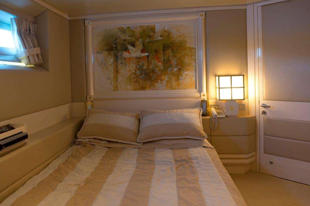 a bed with a painting on the wall aboard CARMEN FONTANA Yacht for Charter