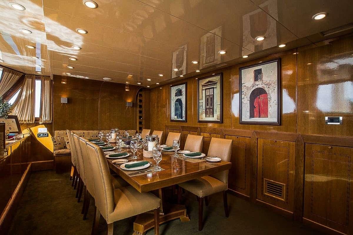 a restaurant with tables and chairs aboard ARKTOS Yacht for Charter