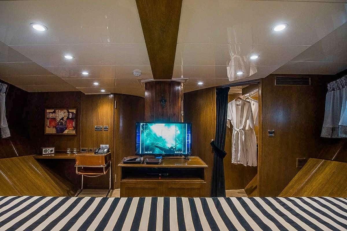 a room with a tv and a table aboard ARKTOS Yacht for Charter