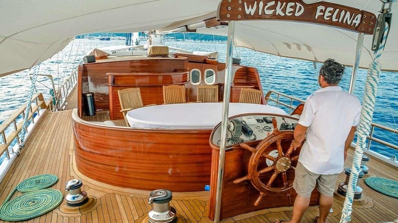 a person standing next to a boat aboard WICKED FELINA Yacht for Charter