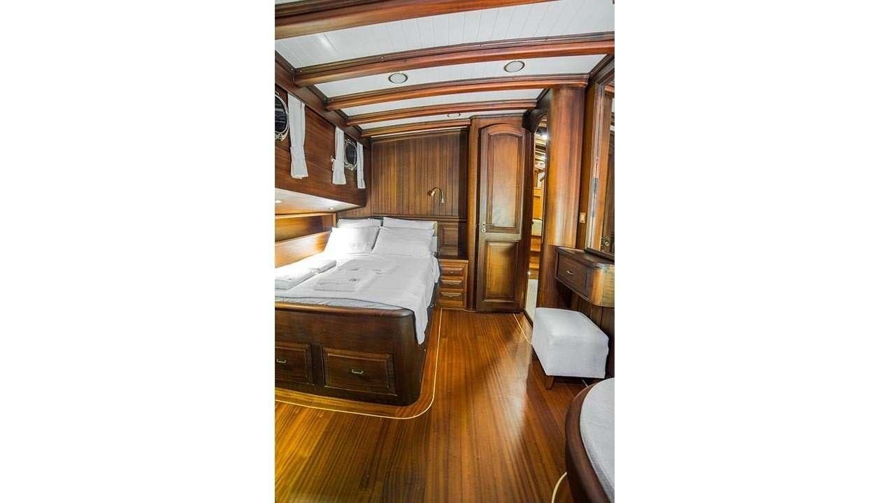 a room with a bed and a dresser aboard WICKED FELINA Yacht for Charter