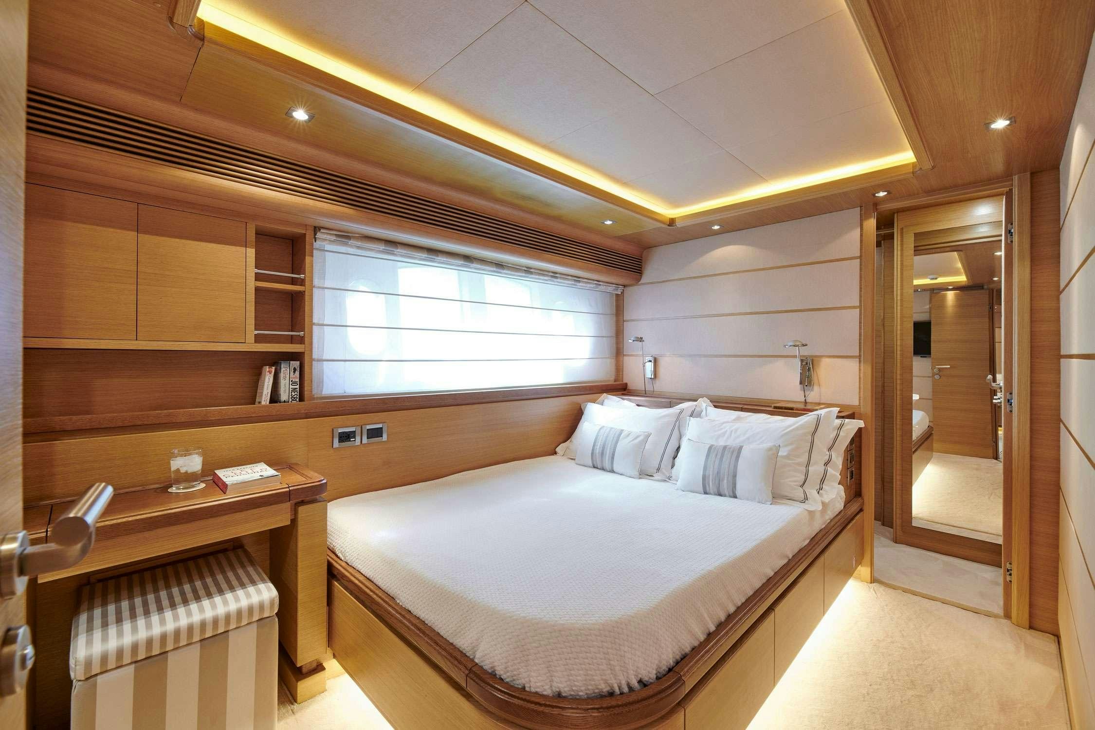 a room with a bed and a desk aboard SEVEN S Yacht for Charter