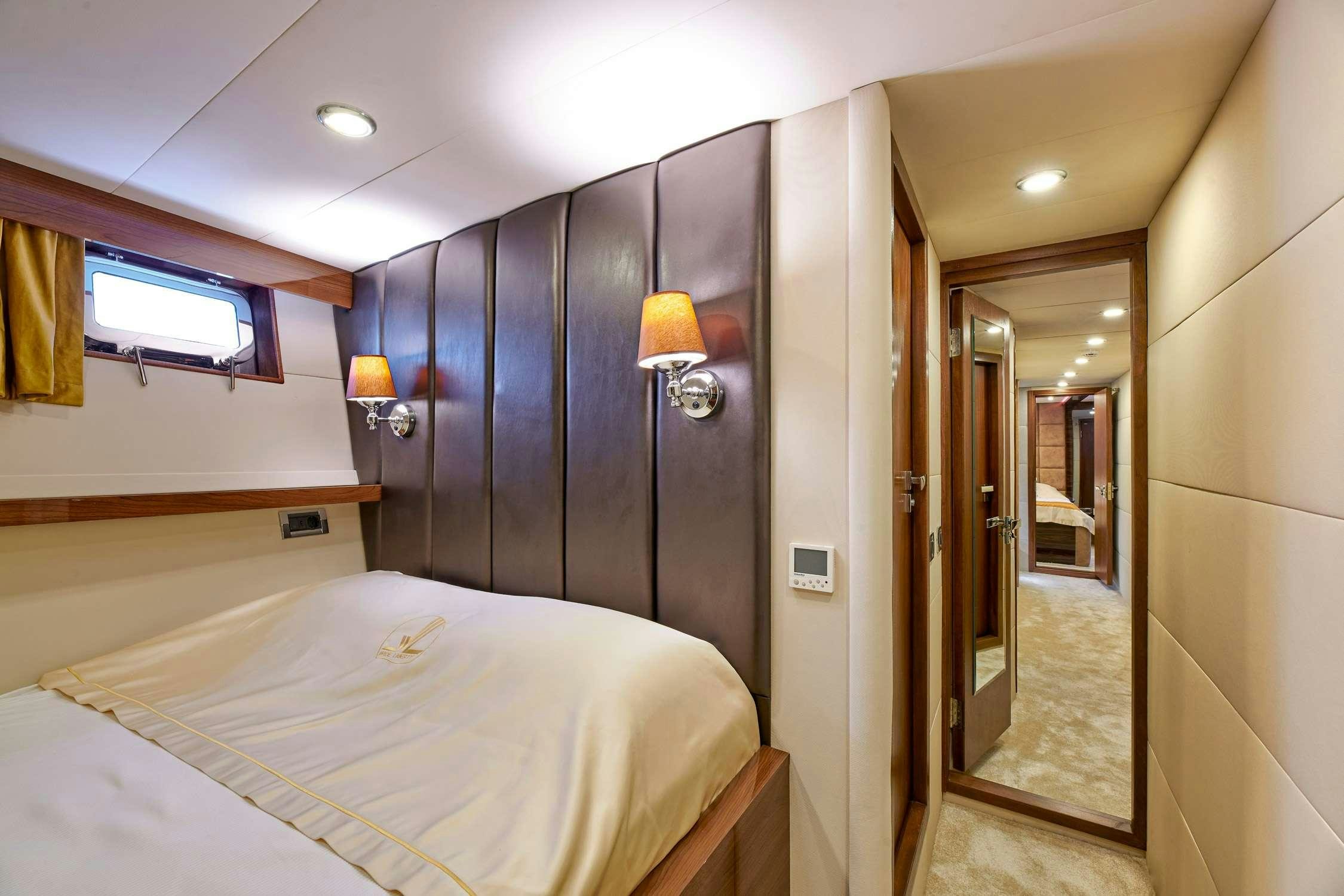 a bedroom with a bed and a mirror aboard WIDE LIBERTY Yacht for Charter