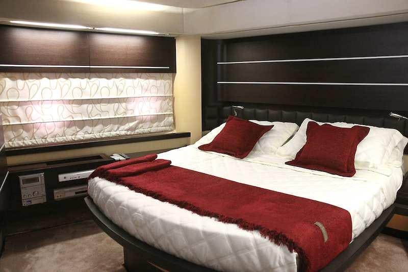 a bed with red pillows aboard SUPER TOY Yacht for Charter