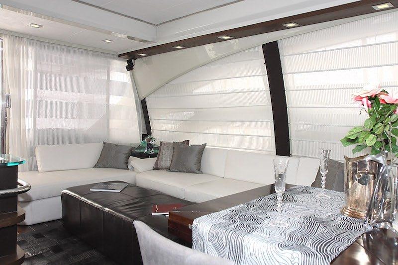 a living room with a large white couch and a large window aboard SUPER TOY Yacht for Charter
