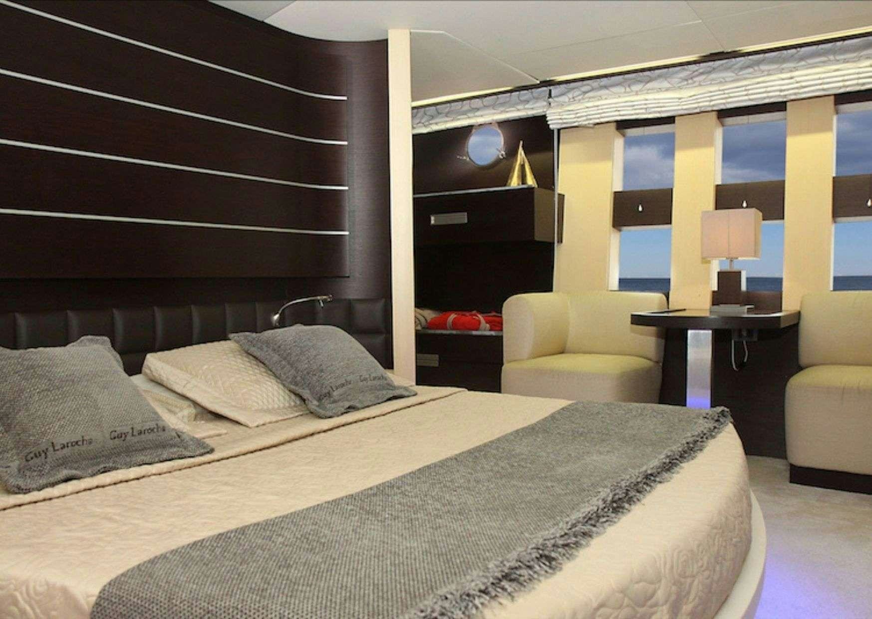 a bedroom with a bed and a desk aboard SUPER TOY Yacht for Charter