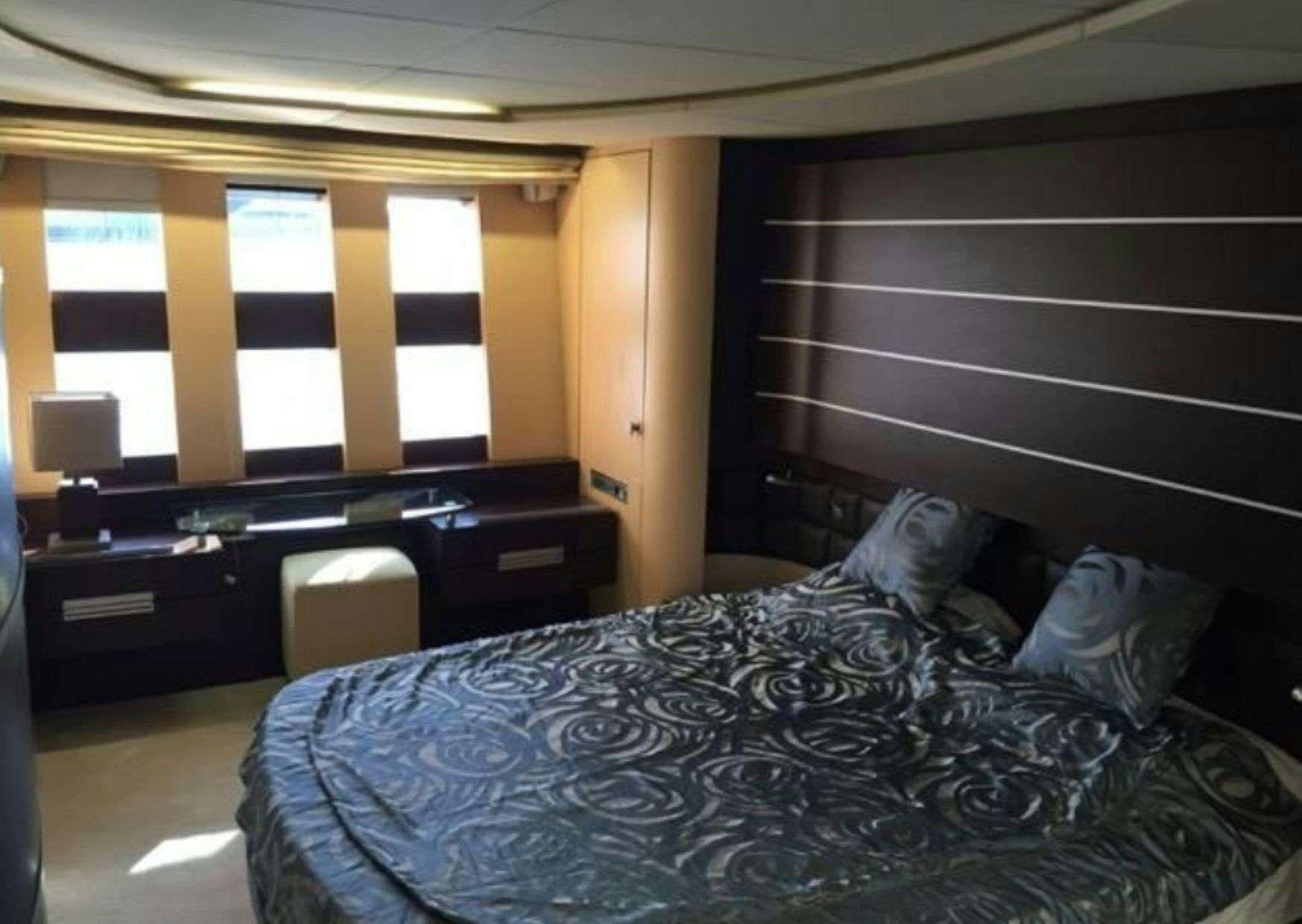 a bedroom with a bed and a desk aboard SUPER TOY Yacht for Charter