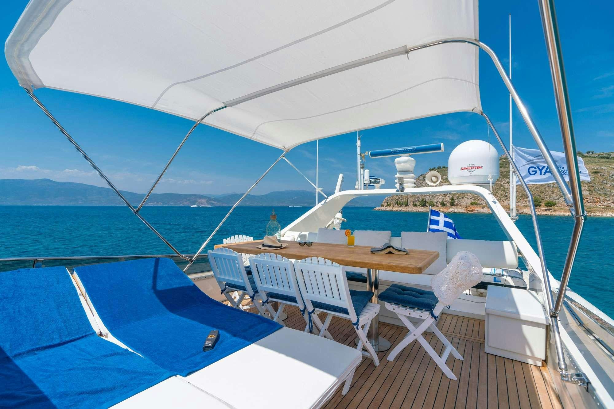 a deck with a boat and chairs on it aboard ALANDINI Yacht for Charter