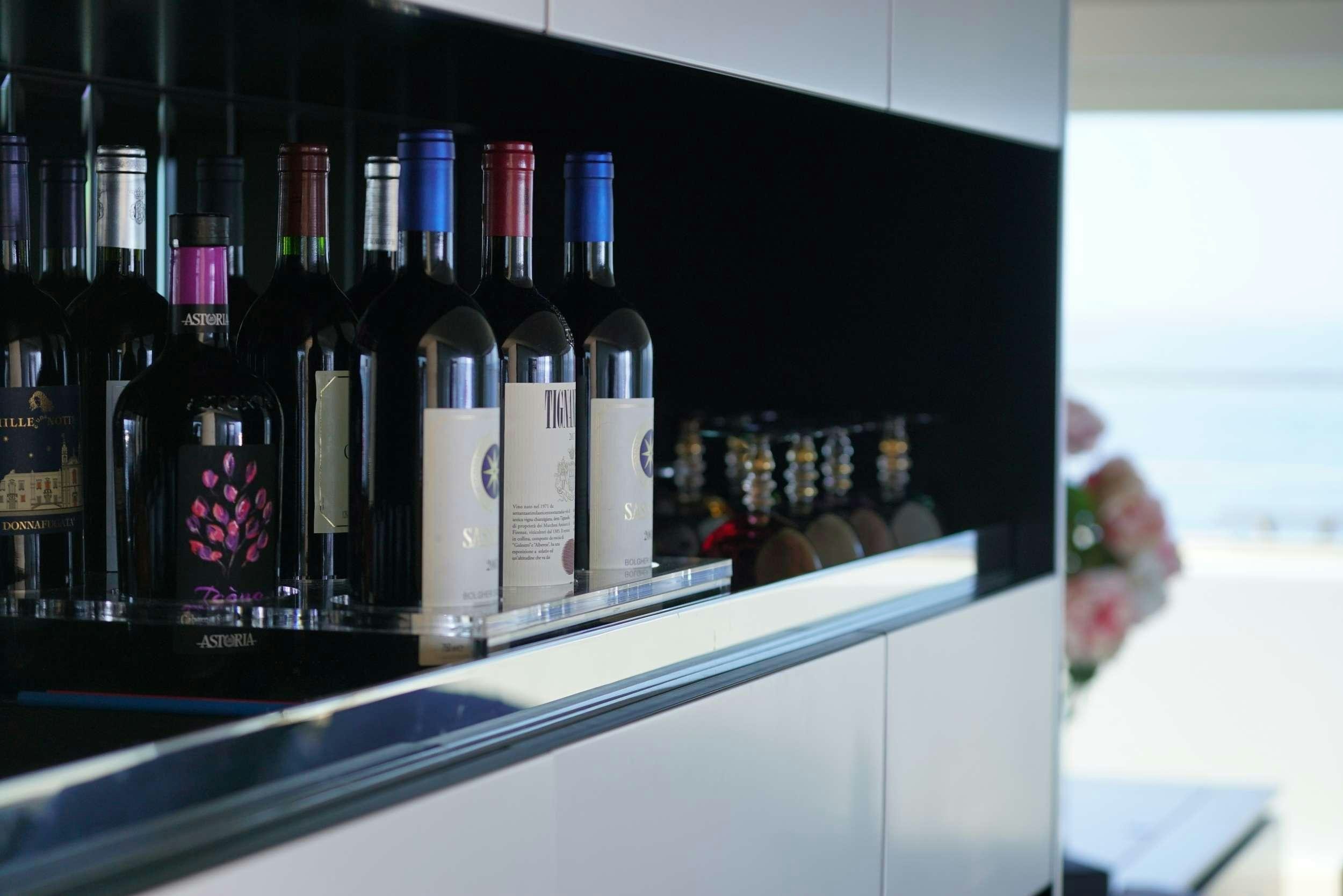 a shelf with bottles of wine aboard GENNY Yacht for Charter