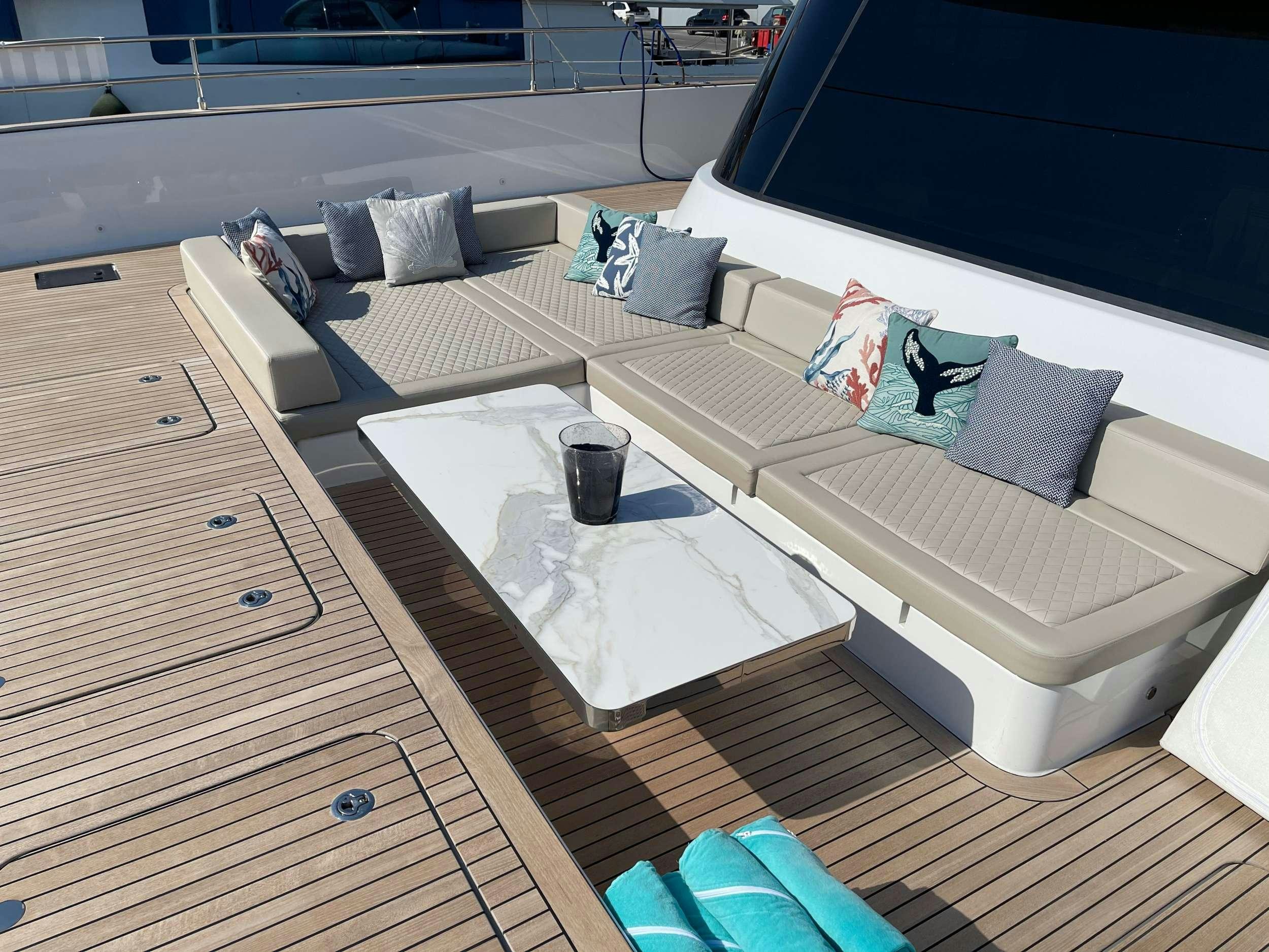 a bed with a coffee table and a coffee cup on it aboard GENNY Yacht for Charter
