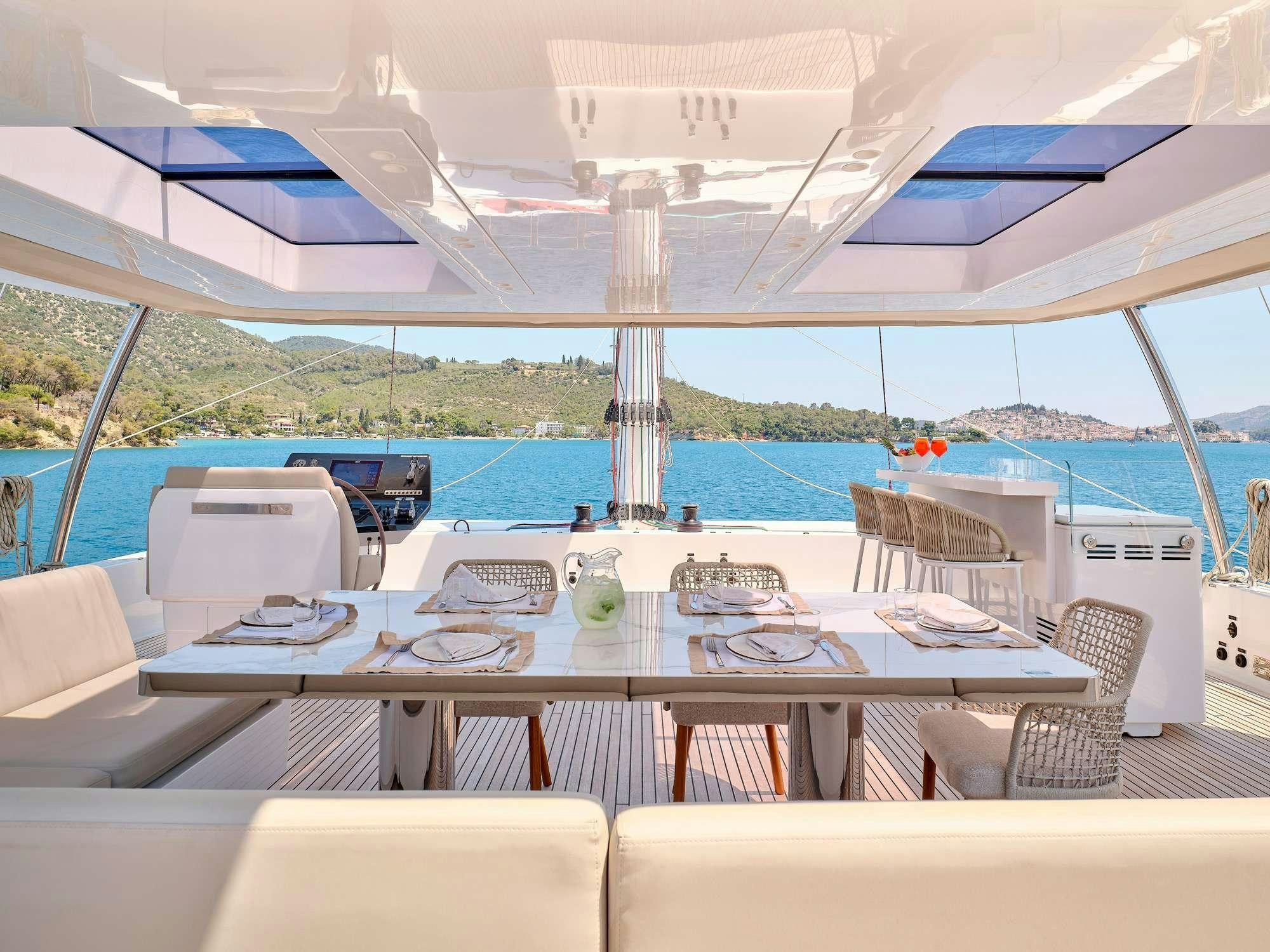 a large white tent with tables and chairs and a view of the water aboard GENNY Yacht for Charter