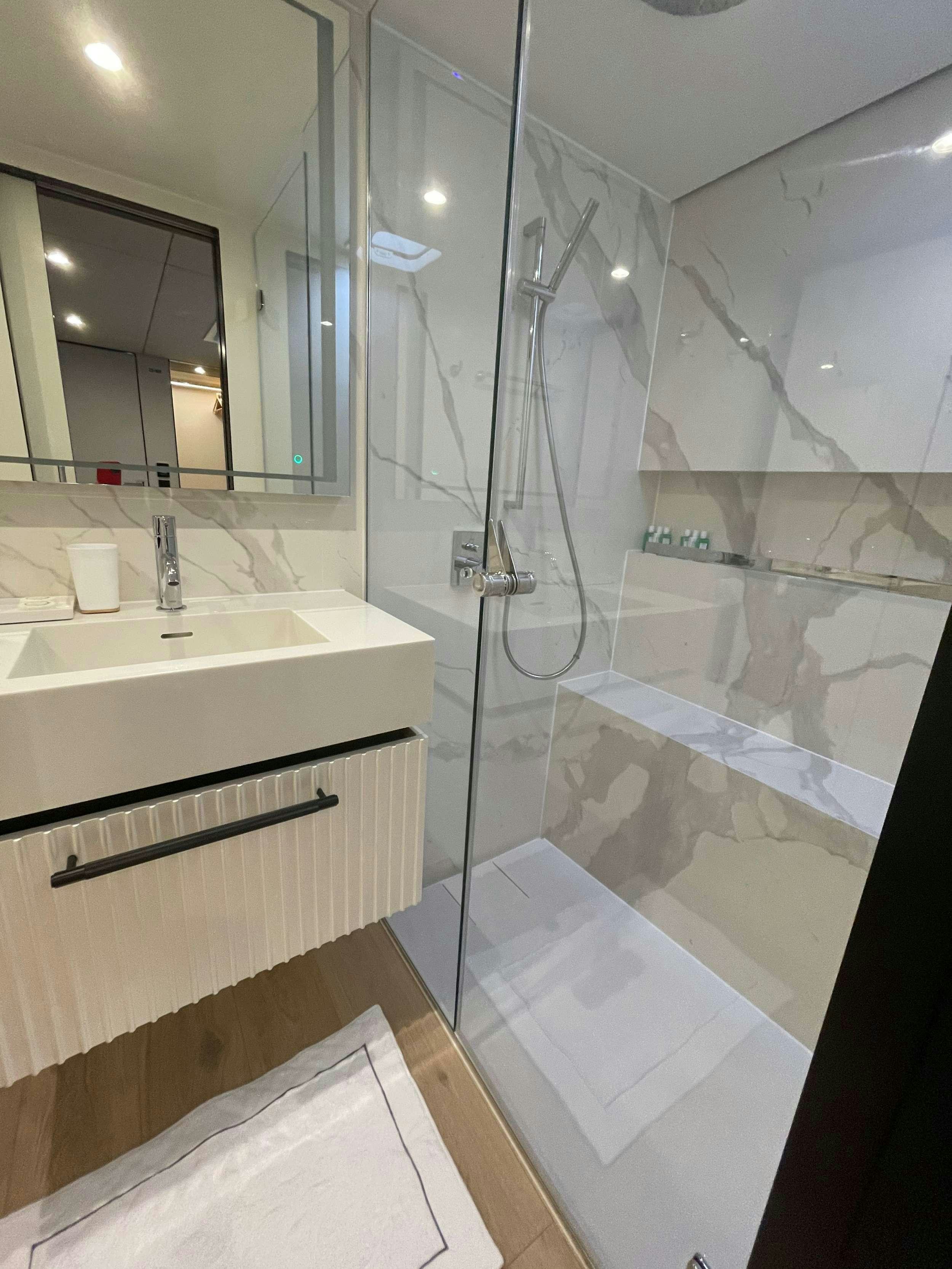 a bathroom with a glass shower aboard GENNY Yacht for Charter