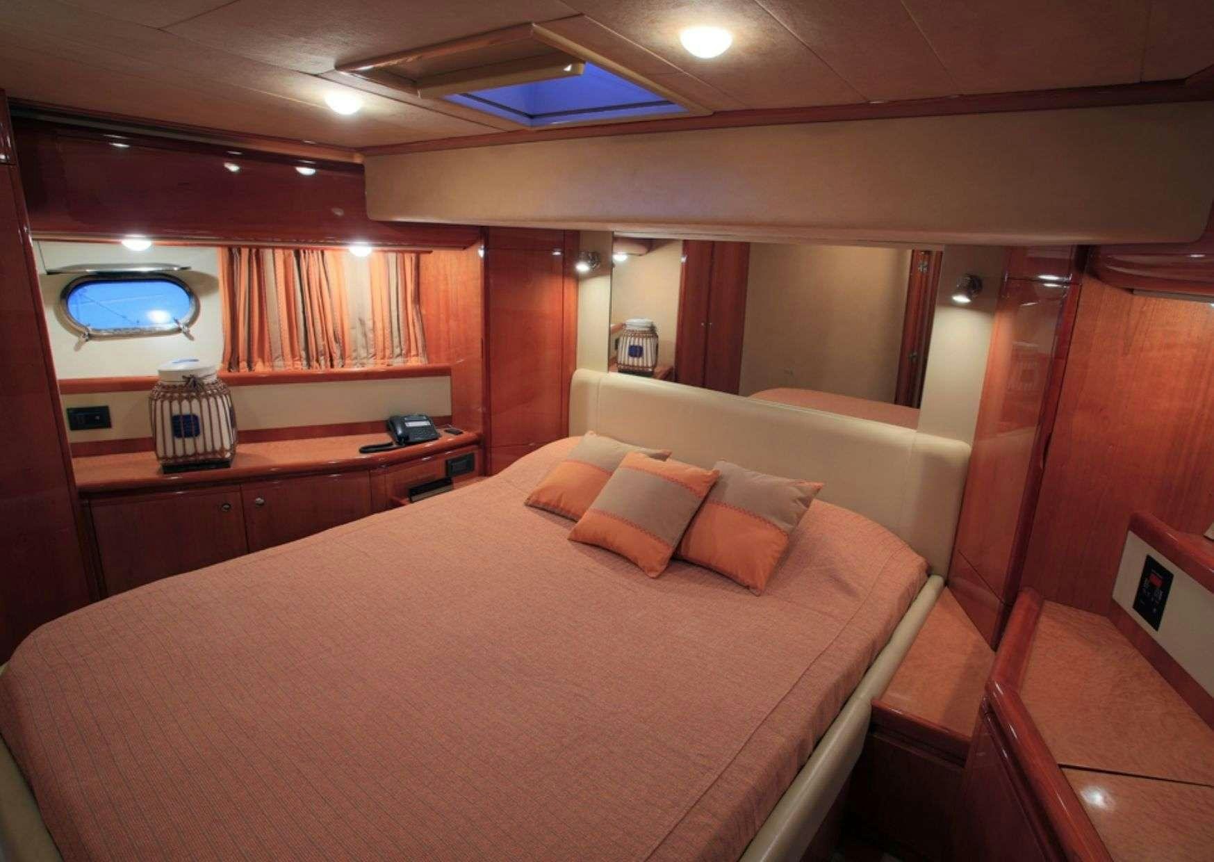 a bed with a white sheet and pillows aboard ADE YIA Yacht for Charter