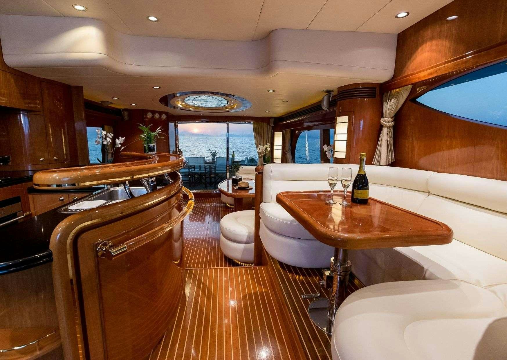 a room with a table chairs and a large window aboard MARLIN Yacht for Charter