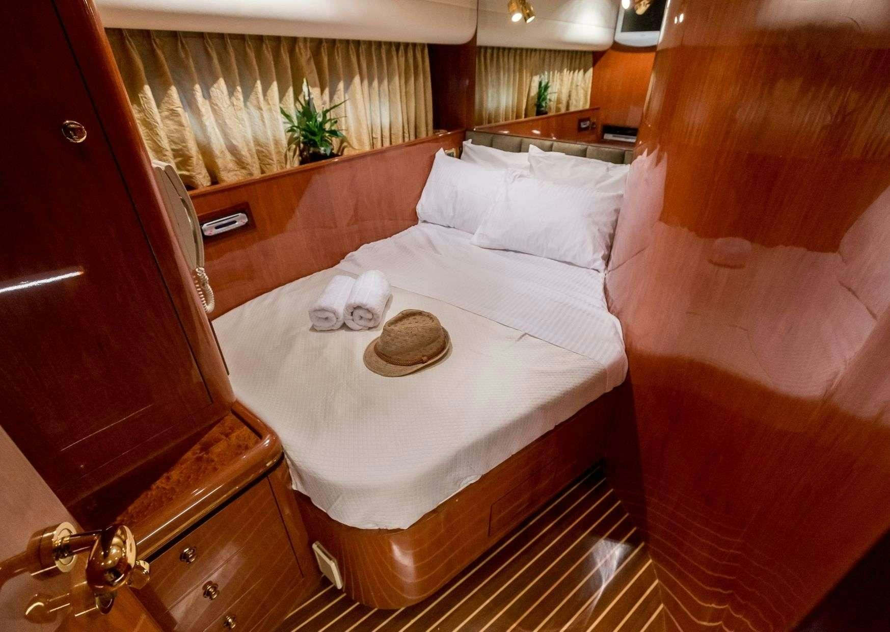 a bed with a white sheet and a brown pillow aboard MARLIN Yacht for Charter