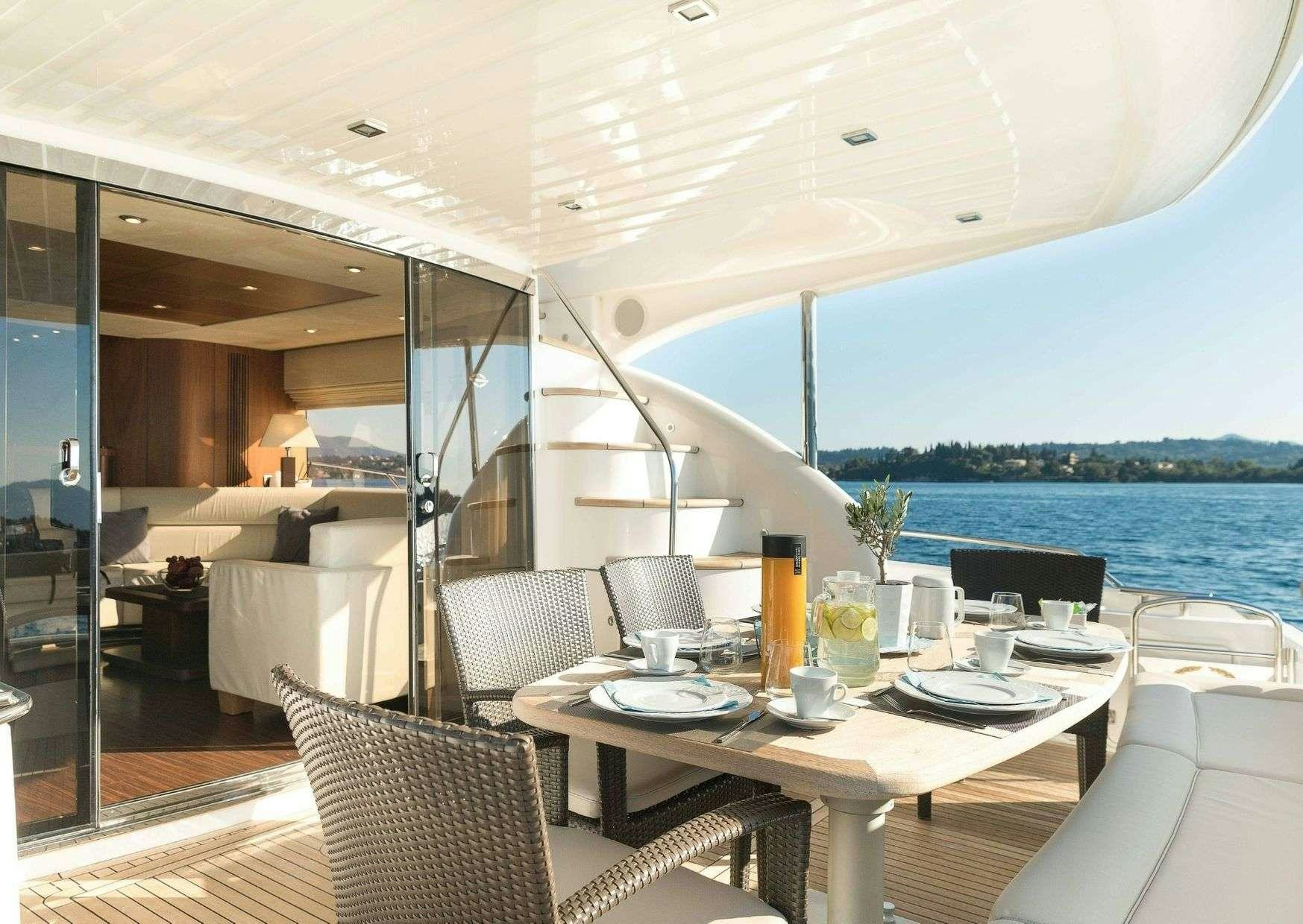 a table with chairs and a view of the water aboard SHINE Yacht for Charter