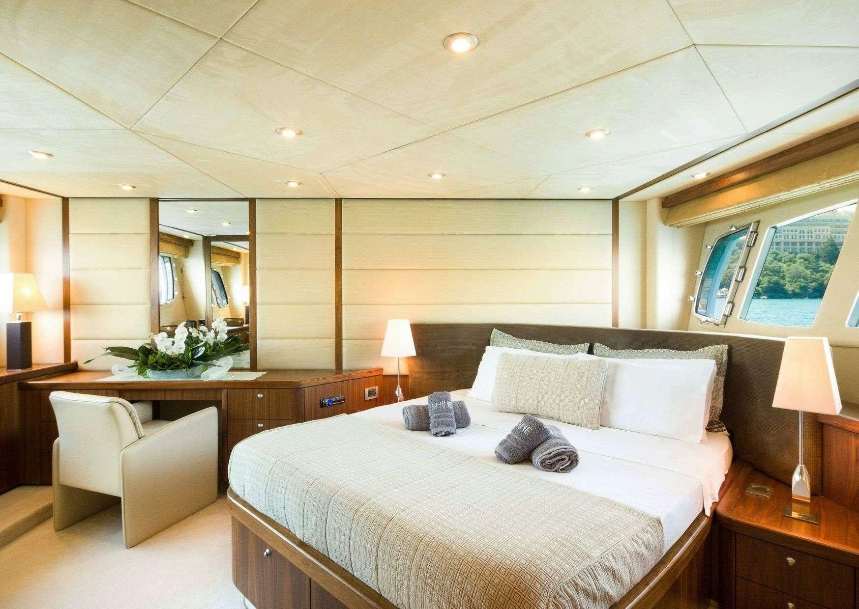 a large hotel room with a large bed and a desk aboard SHINE Yacht for Charter