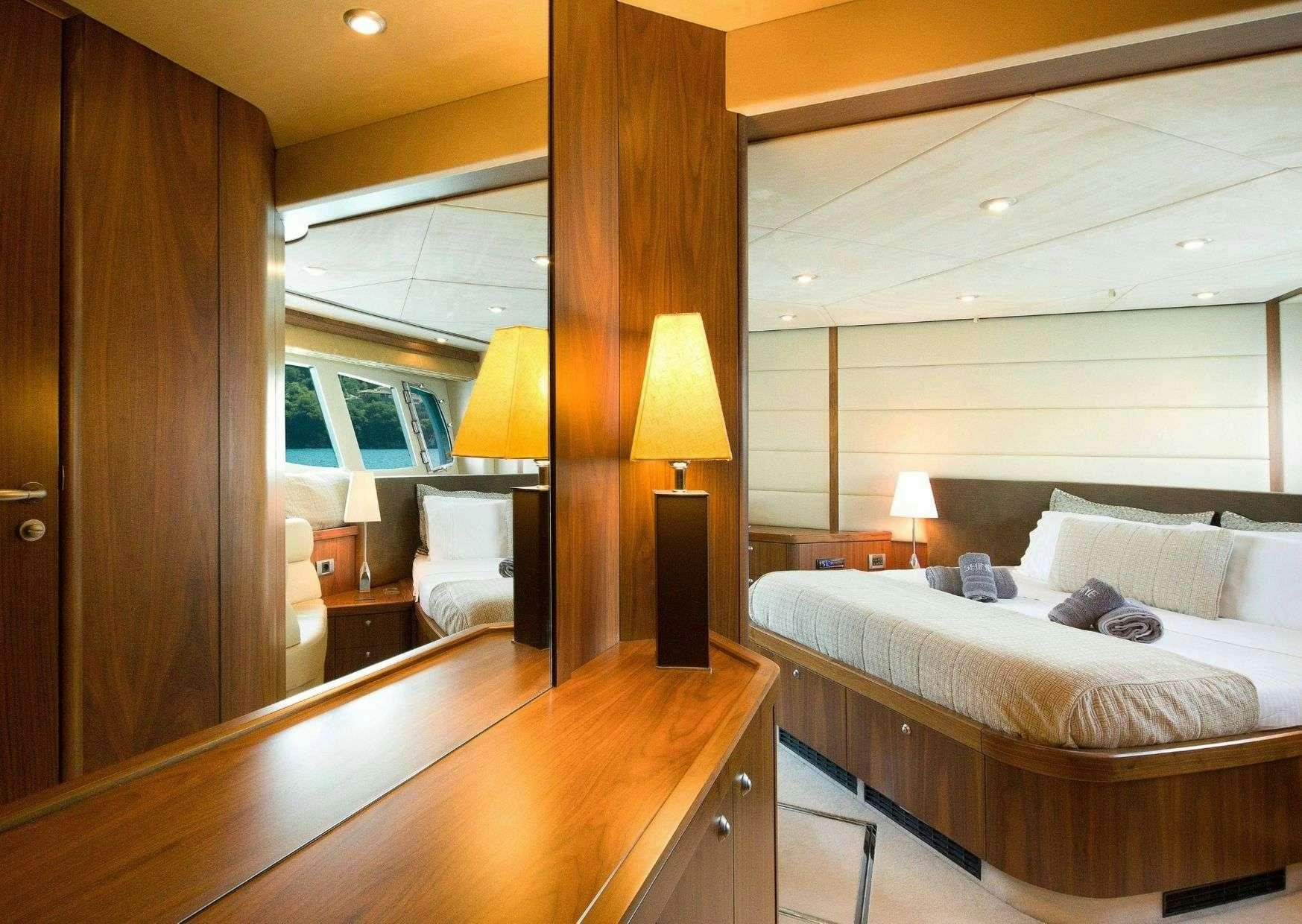 a bedroom with a bed and a lamp aboard SHINE Yacht for Charter