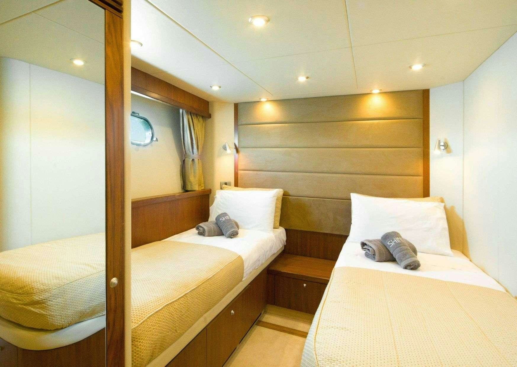 a couple of beds in a hotel room aboard SHINE Yacht for Charter