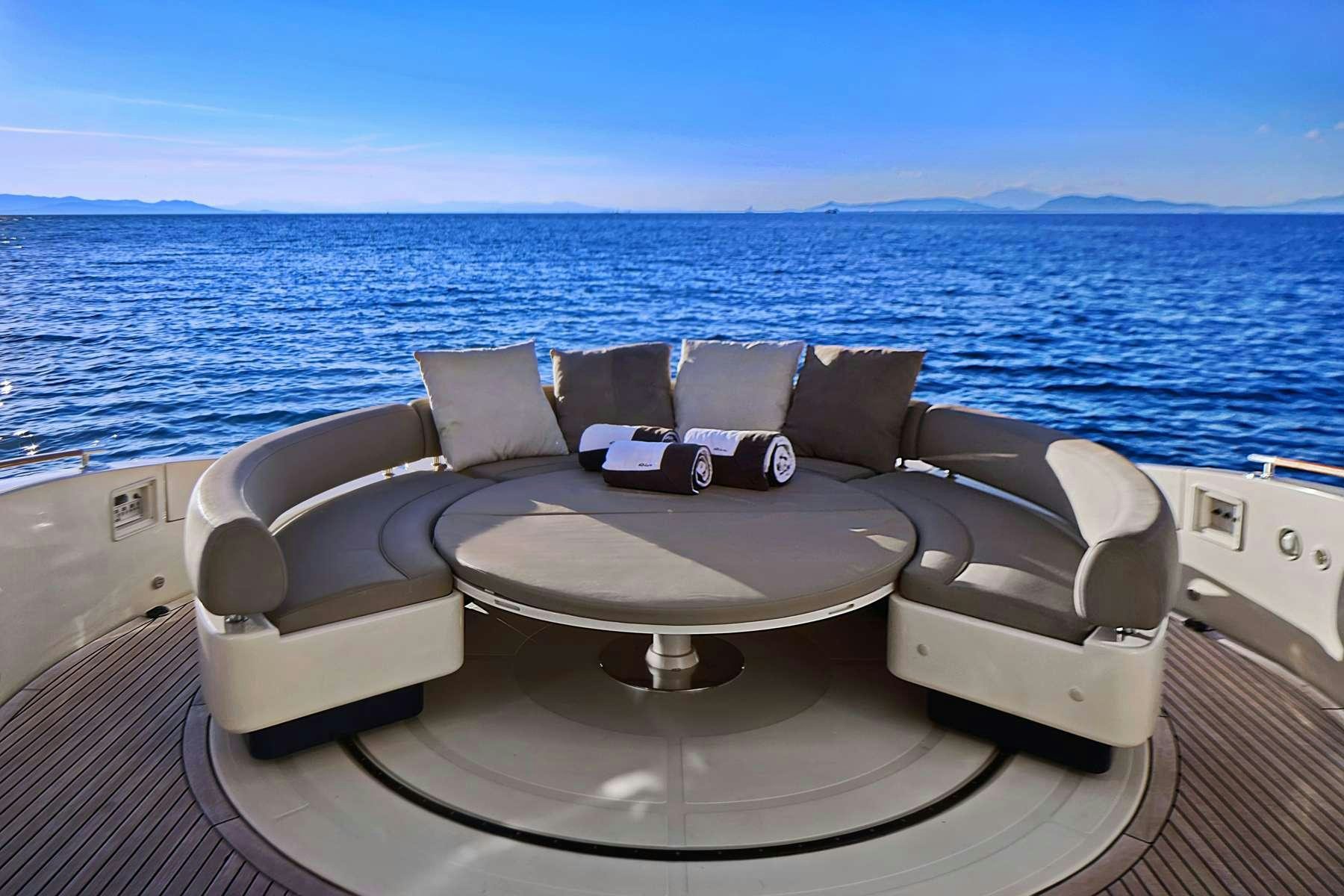 a lounge chair on a deck overlooking a large body of water aboard SEA U Yacht for Charter