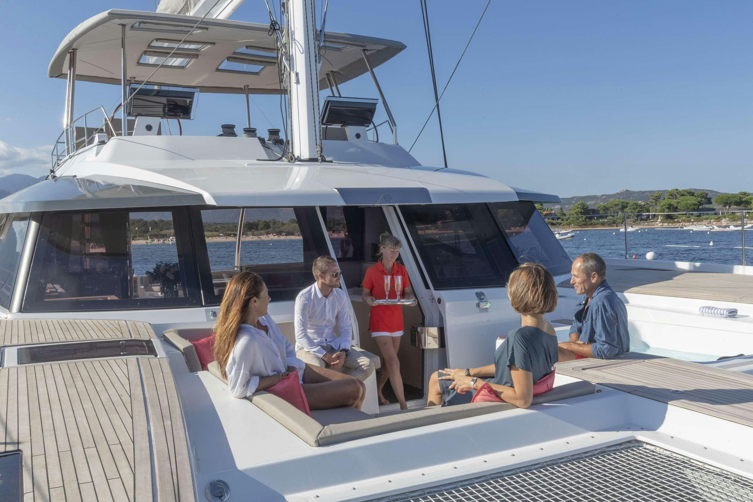 a group of people sitting on a boat aboard KIMATA Yacht for Charter