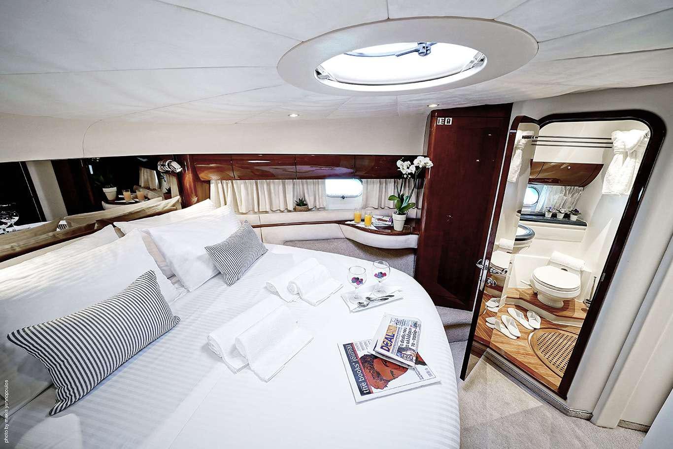 a room with a bed and a table aboard DISTAR PRINCESS Yacht for Charter