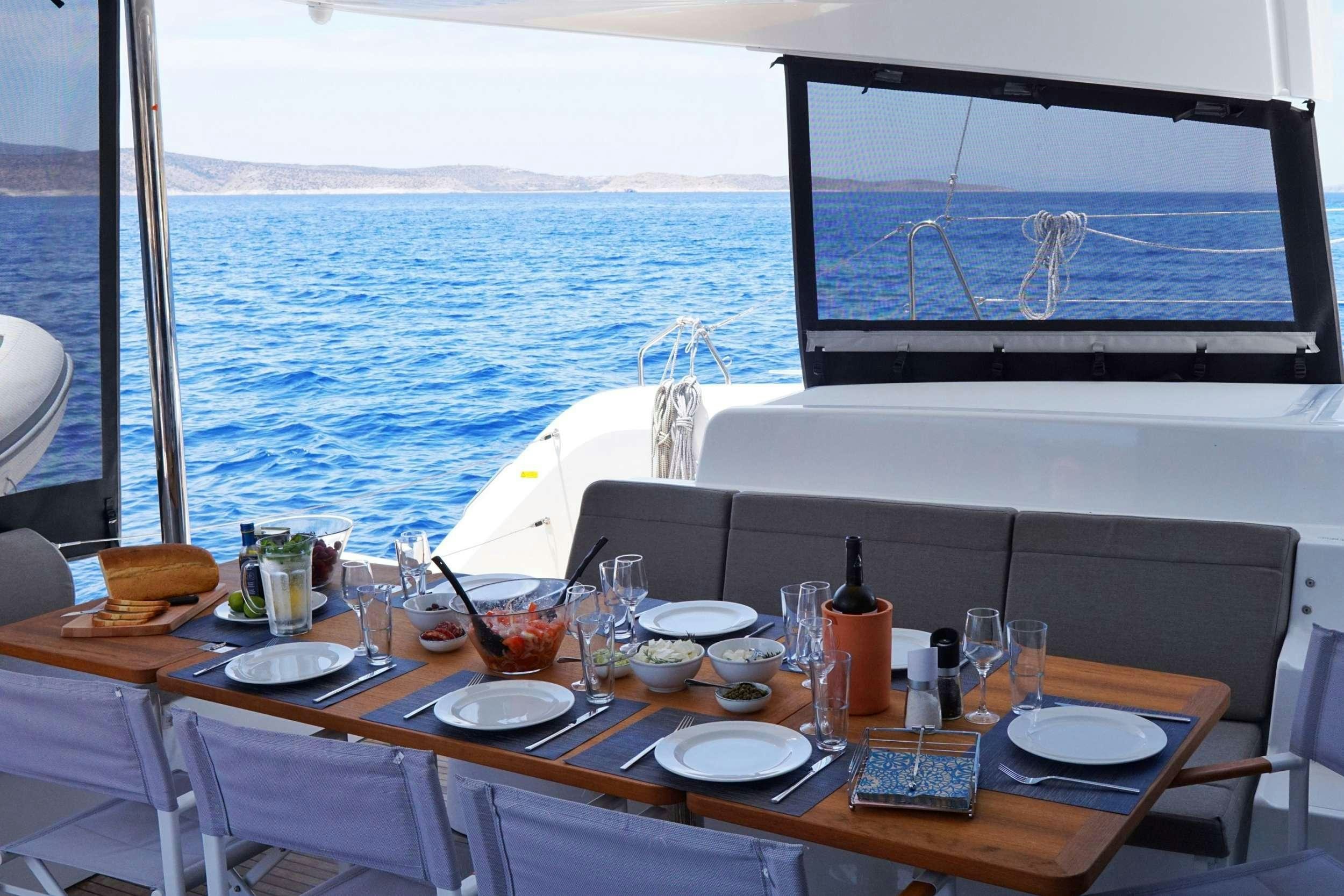 a table with plates and glasses on it aboard ANDIAMO Yacht for Charter
