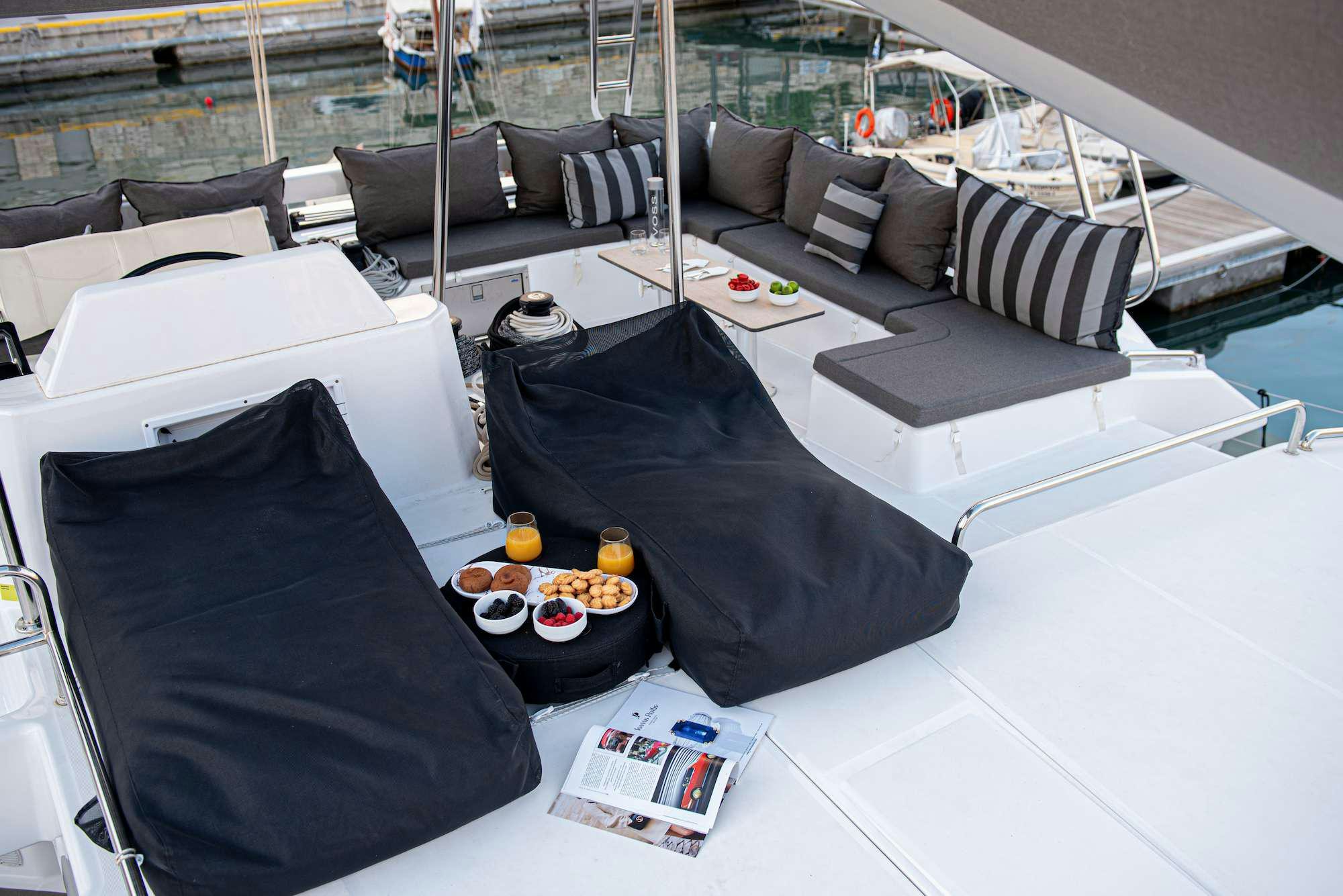 a room with a couch and a table with food on it aboard MY BLUE HEAVEN Yacht for Charter