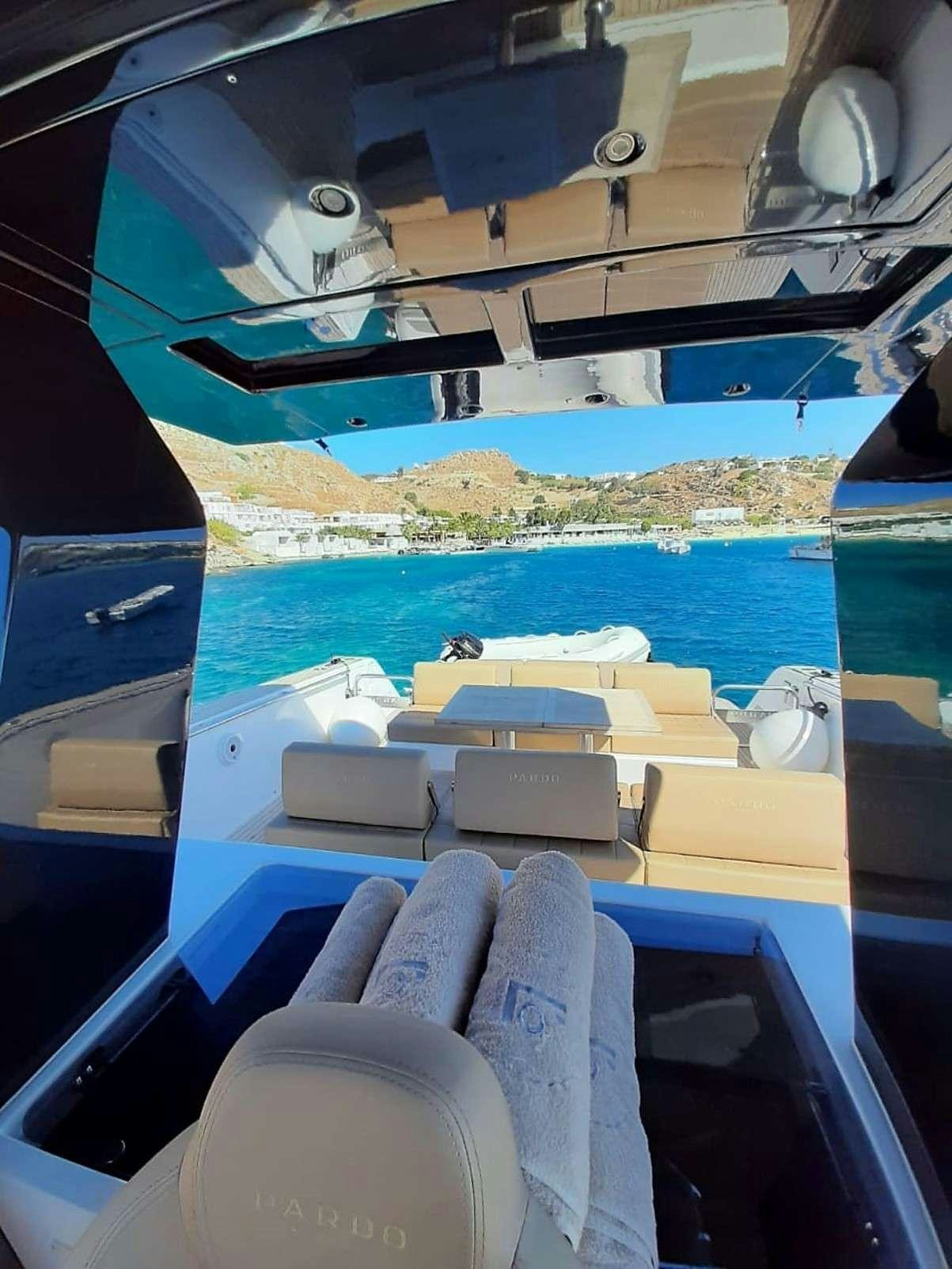 a boat with seats and a body of water in the background aboard BABY D Yacht for Charter